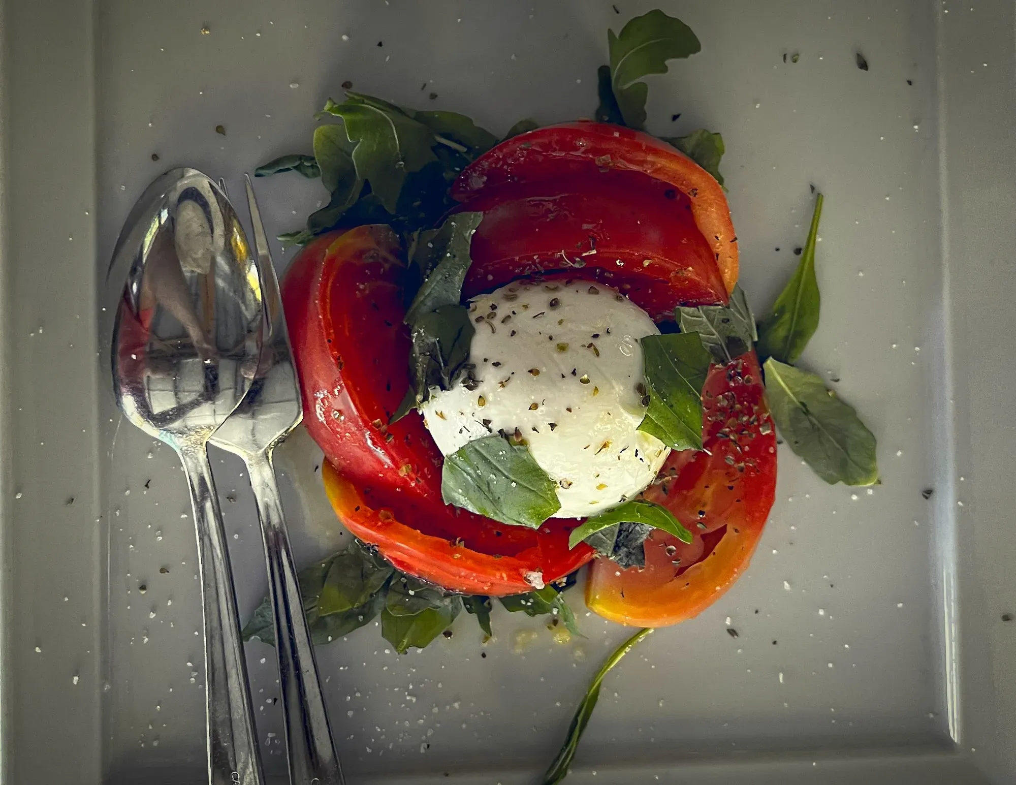 Caprese Salad. Overhead shot next to spoon and fork.