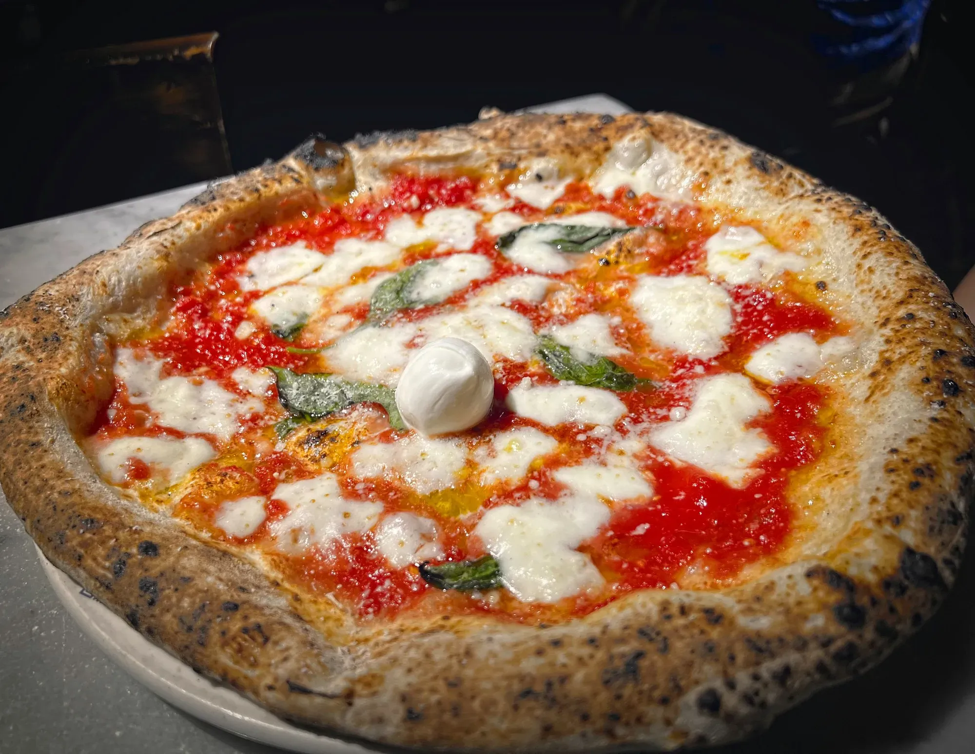 Neapolitan pizza. Low angle of a margherita pizza with a ball of mozzarella in the middle.