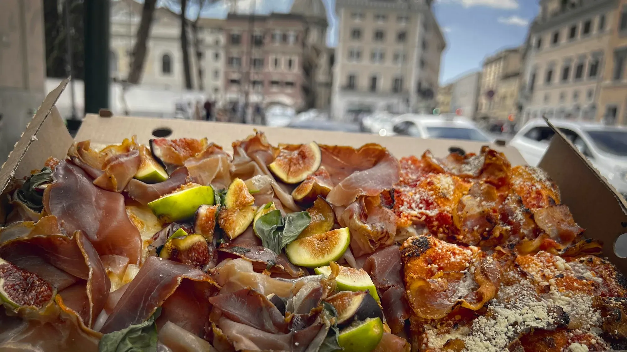 Roman-style pizza. Angled shot with Roman architecture in the background.