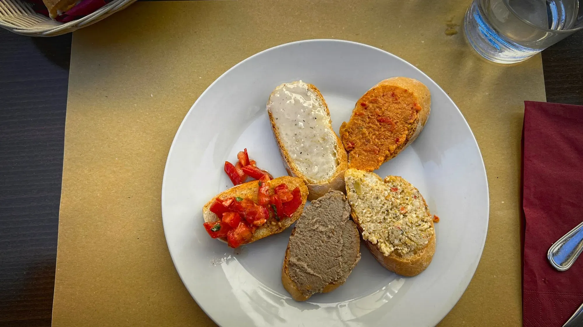 Crostini Toscani. Overhead shot of 5 different regional toppings with table setting.