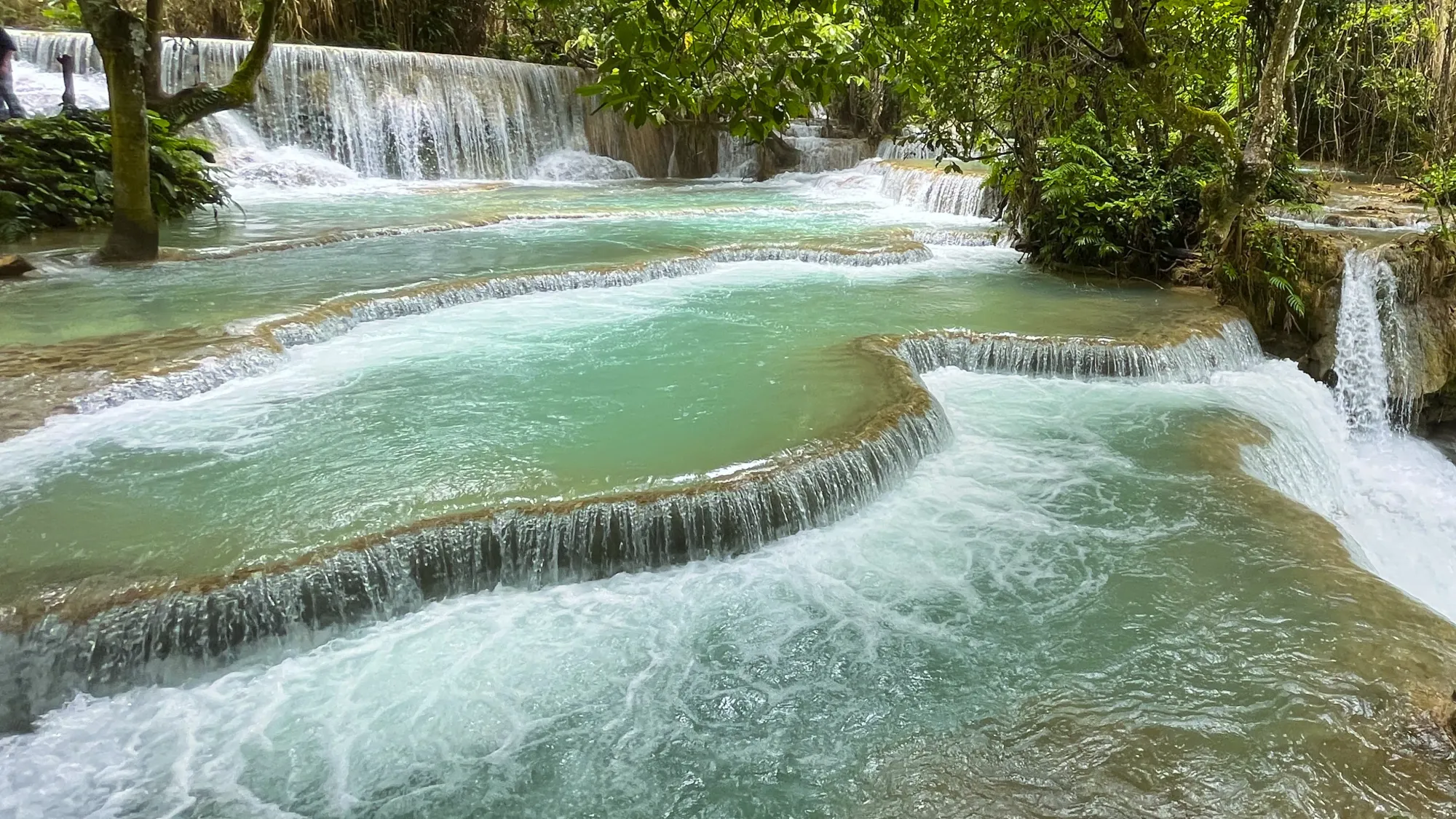 Successive waterfalls with aqua water at the Kuang Si Falls