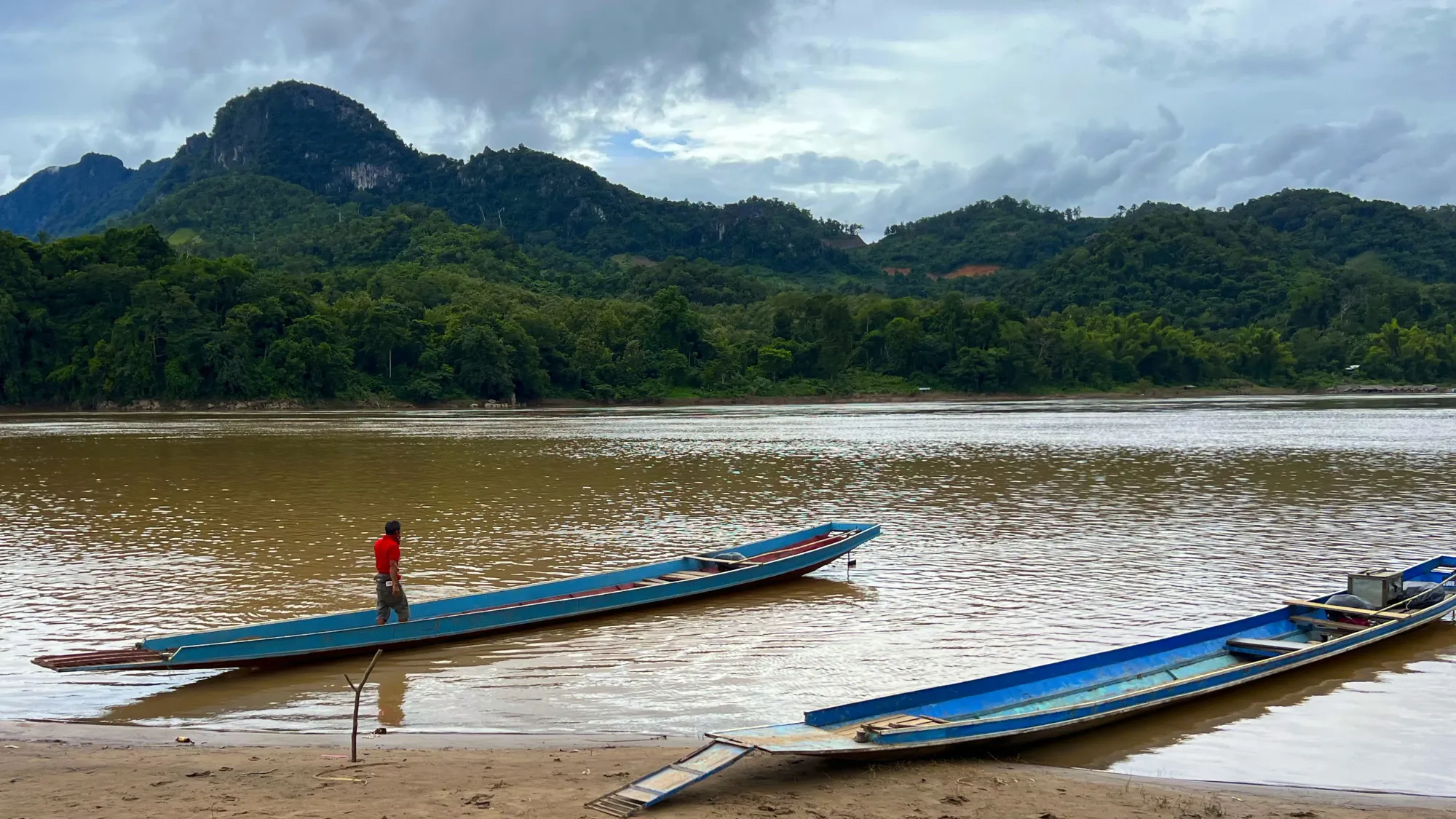 Day shot of two long boats on the Mekong River