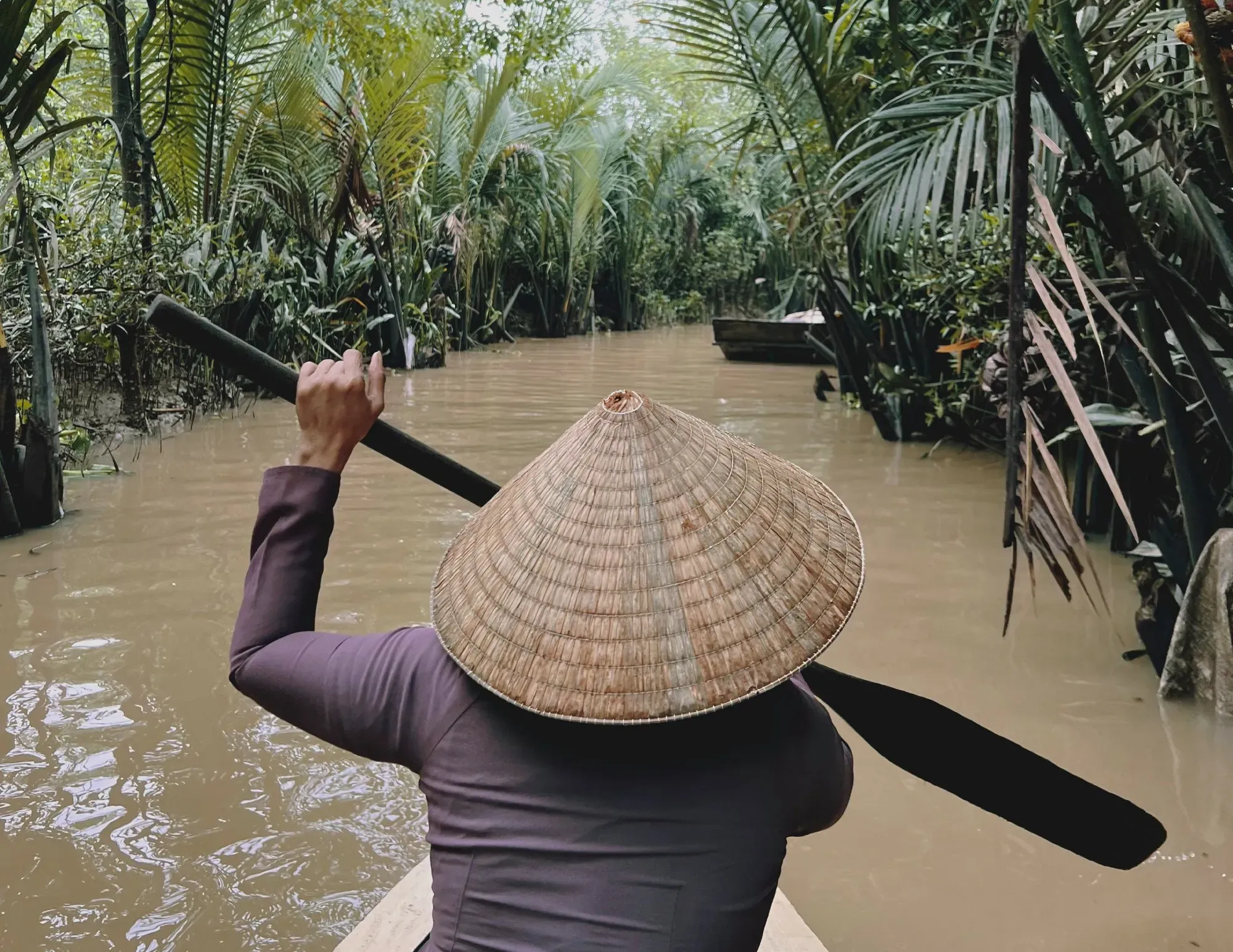 Paddling through the Mekong delta on small boat.