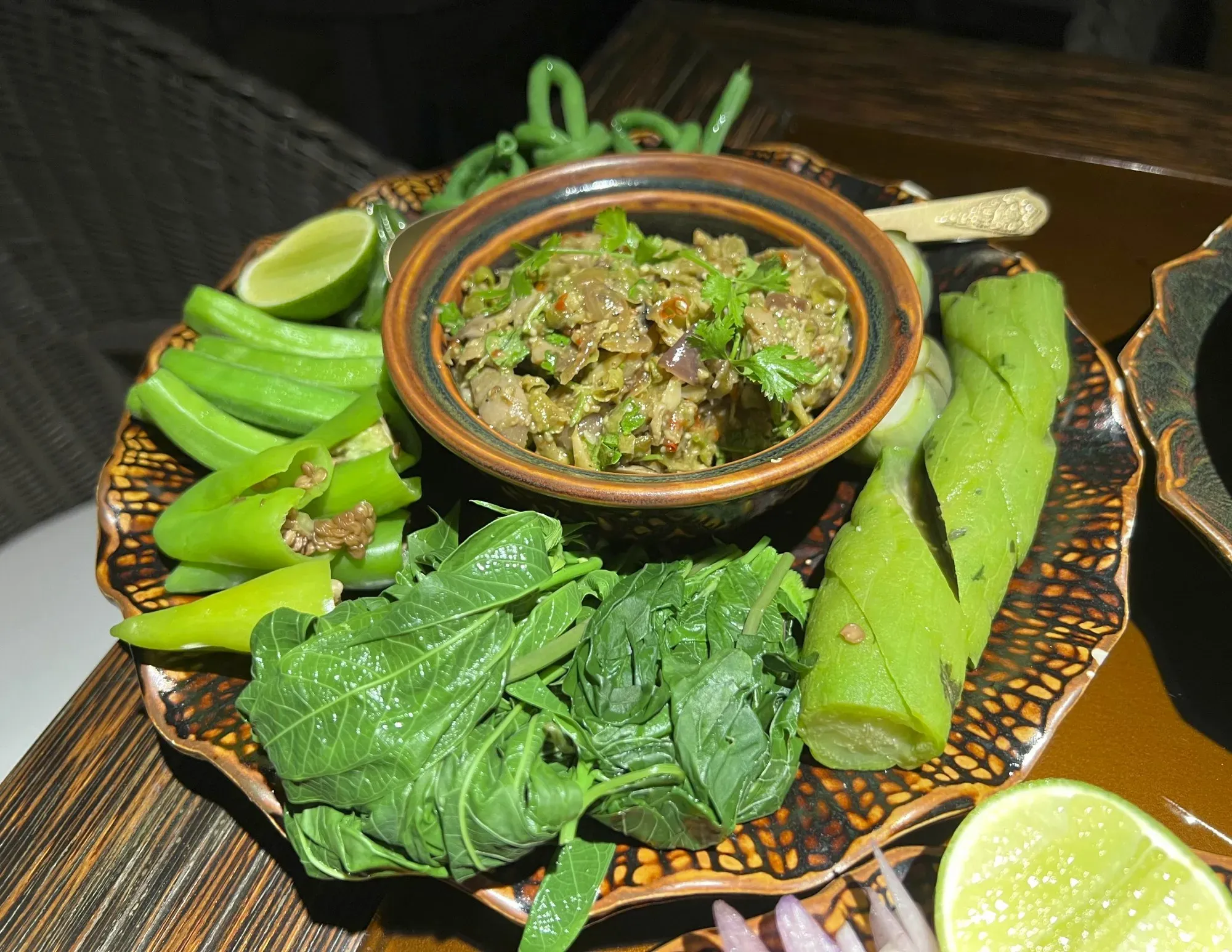 Small dish of Bok Trop Pgnon served surrounded by exclusively green vegetables.