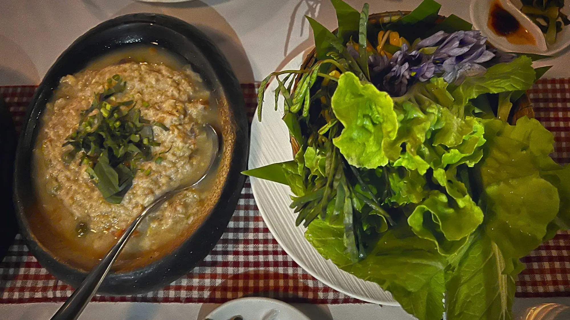 Plate of Tek Kroeung served with fresh greens and flowers.