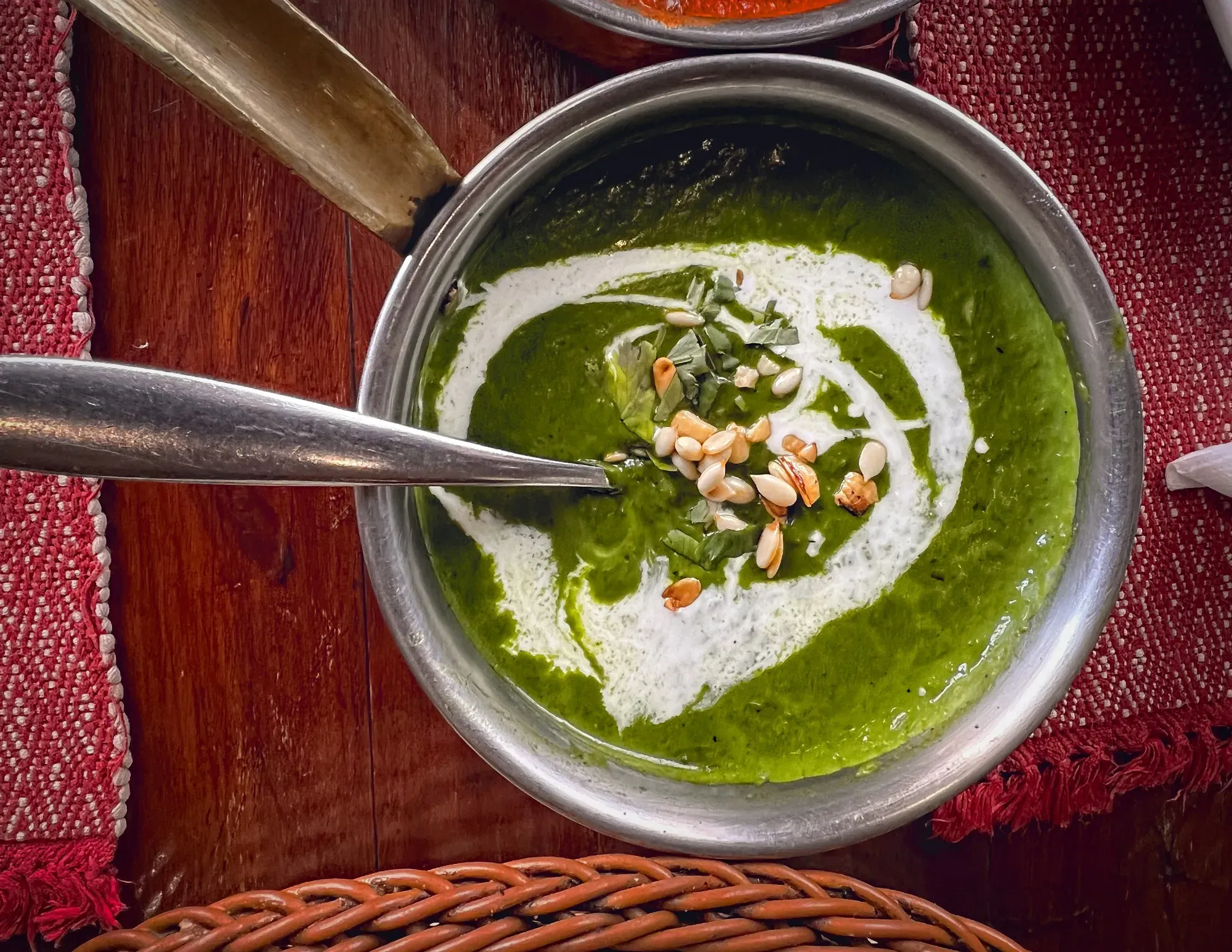 Palak paneer in a metal saucepan, overhead shot.