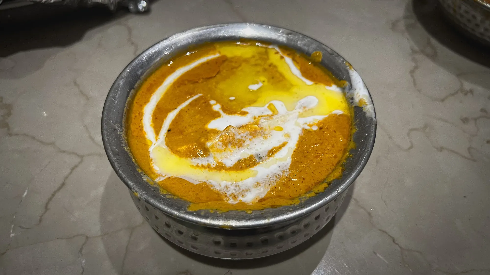 Angled shot of a bowl of Shahi Paneer.