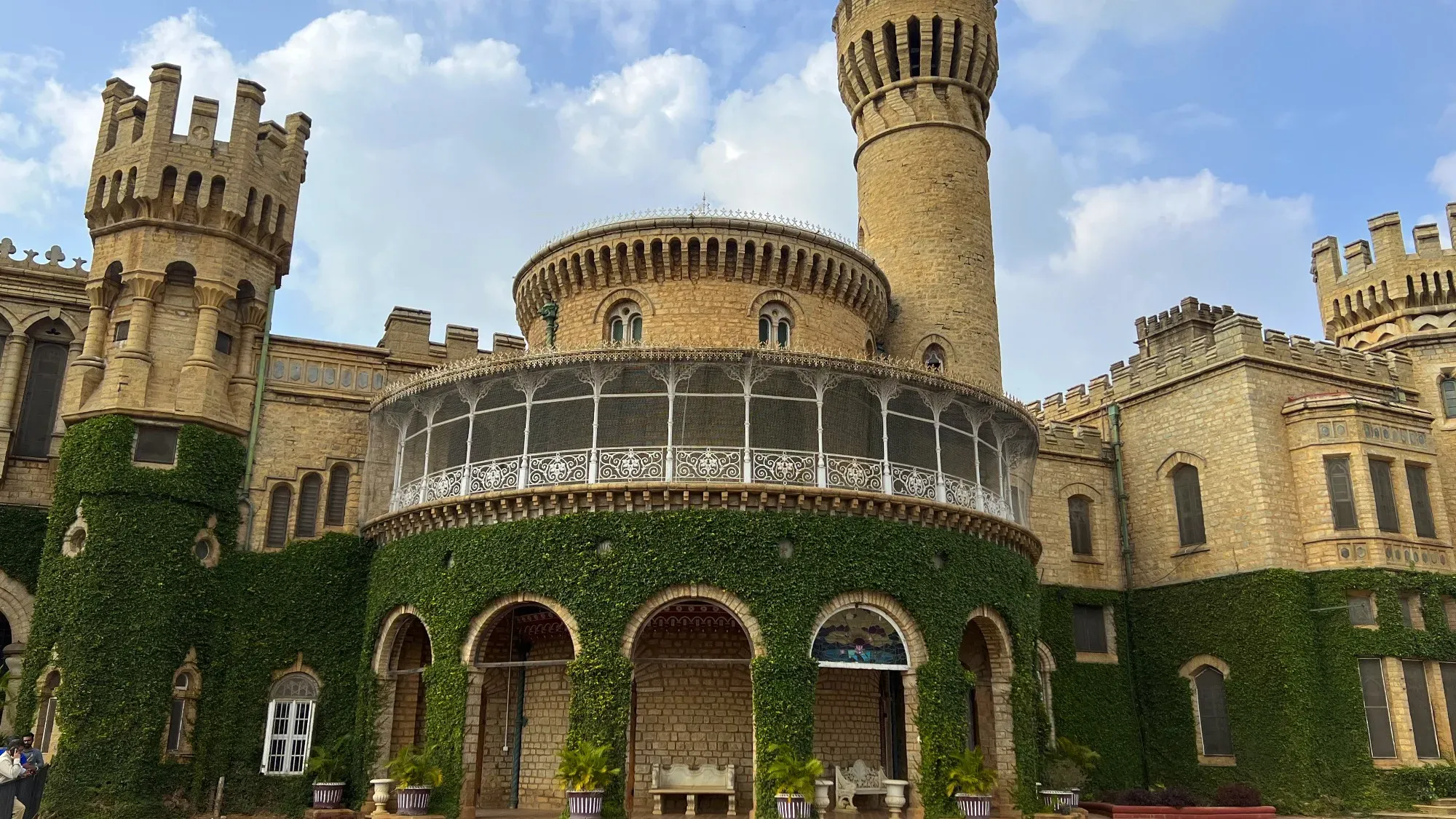 Tan stone palace with the first floor covered in green ivy