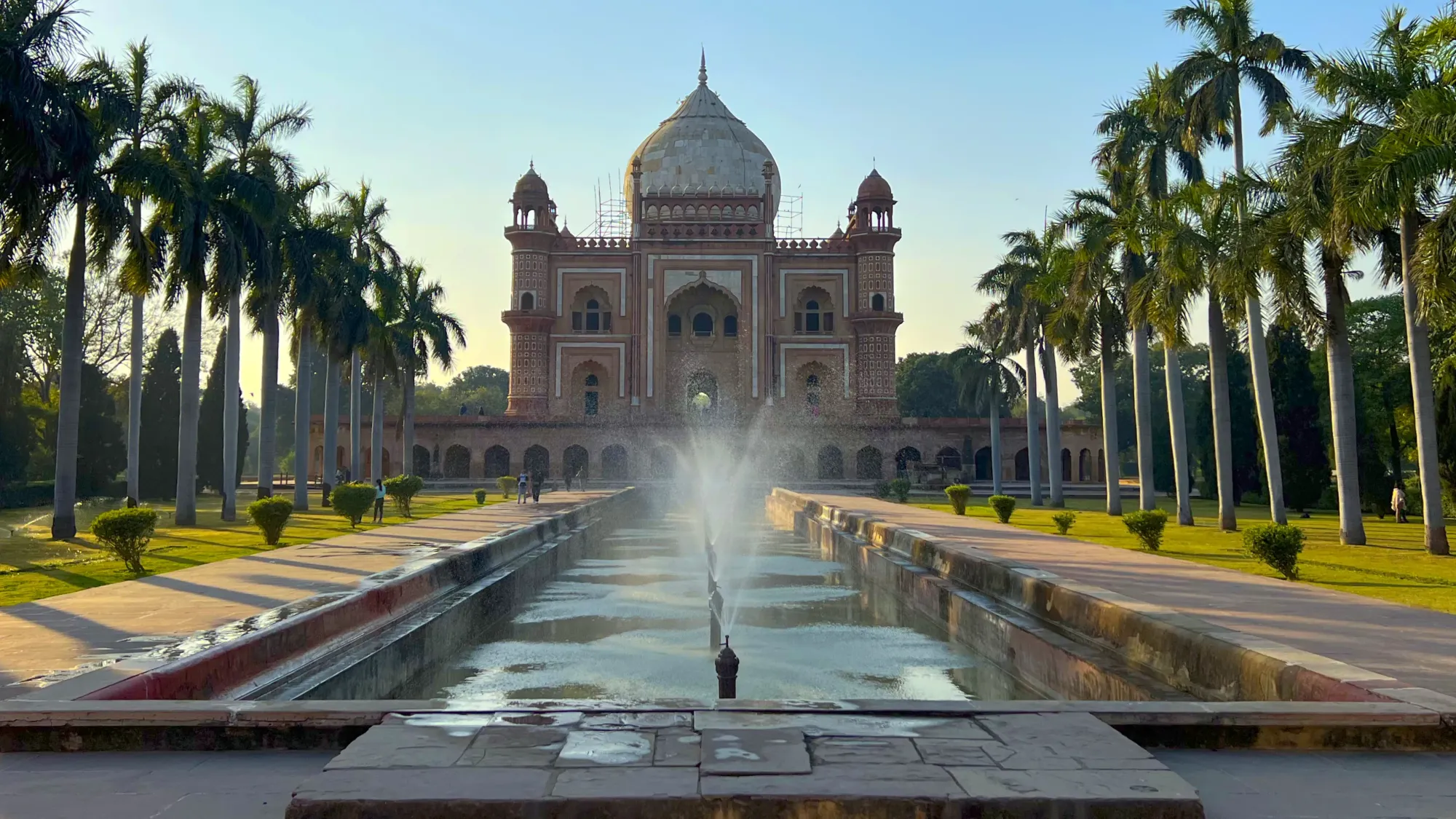 Center fountain with palm trees lining the lane pointing at the onion domed tomb