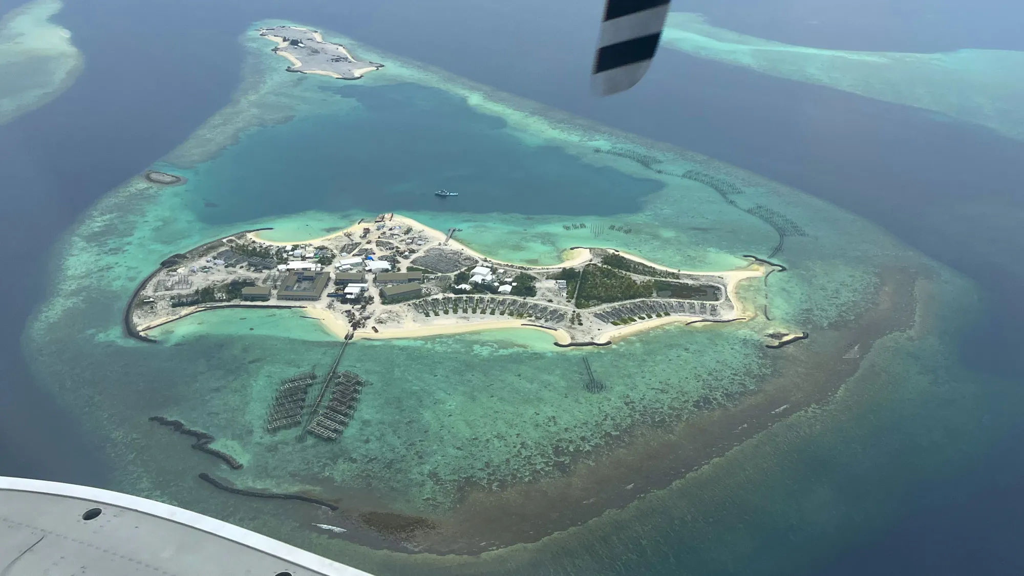 Aerial image of an island resort with shallow turquise water around it