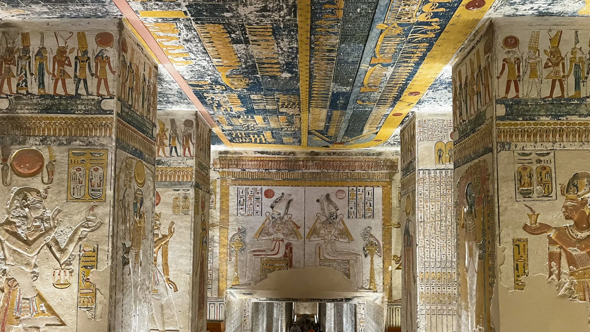 Red, yellow, and blue painted reliefs and hieroglyphics on the walls of the tomb