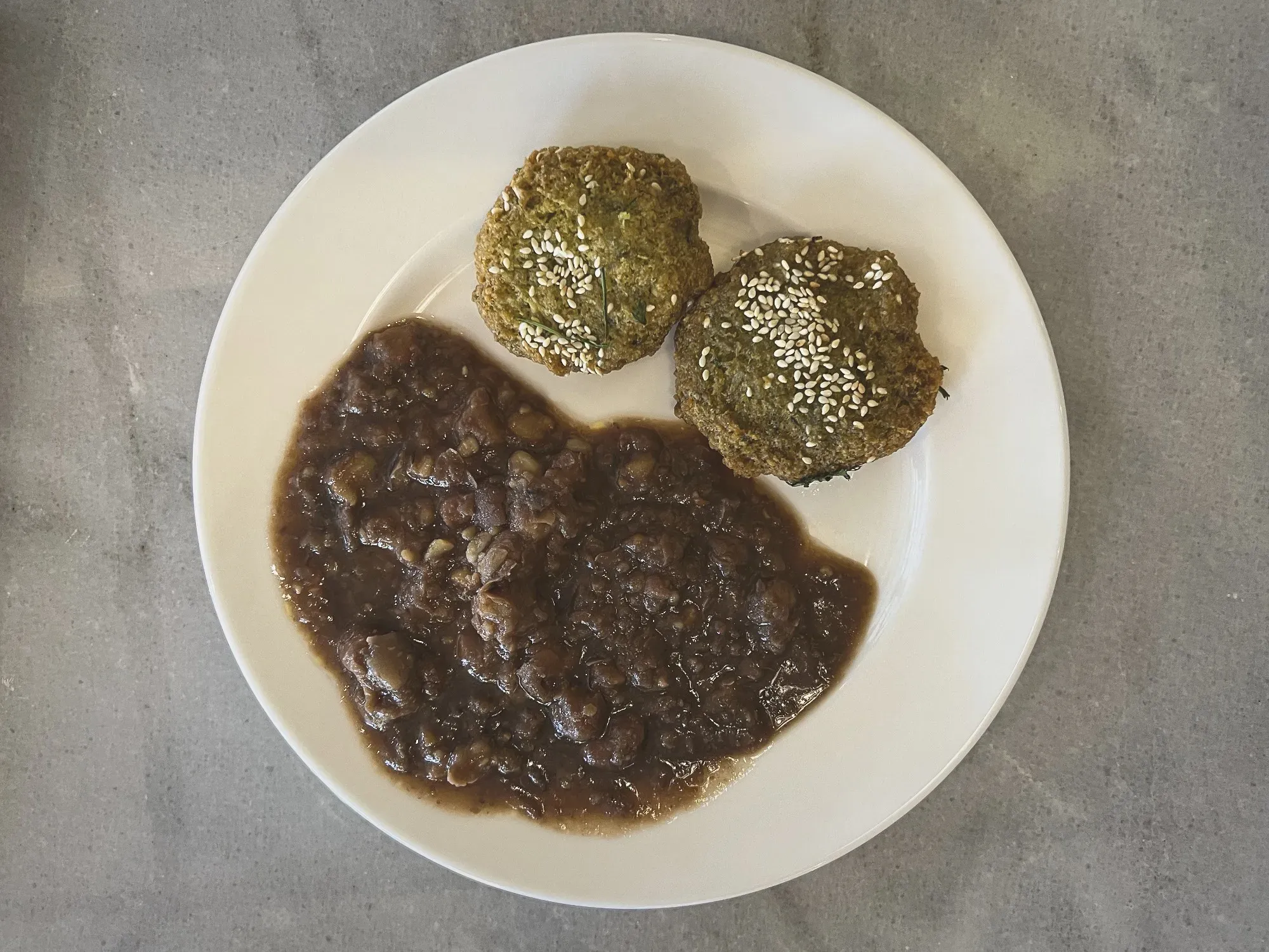 Two Ta'ameya on a plate with ful medames, overhead shot.