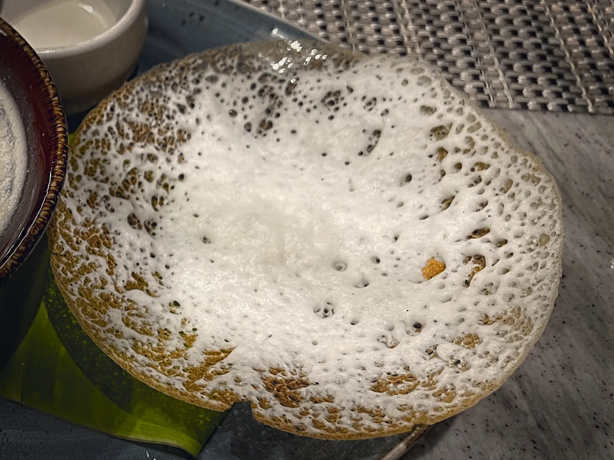 Angled, close up shot of an Appam.