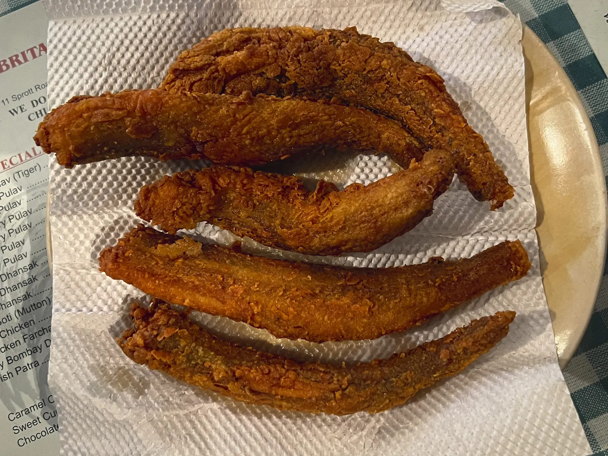 Five pieces of Bombay Duck on a napkin, overhead shot.