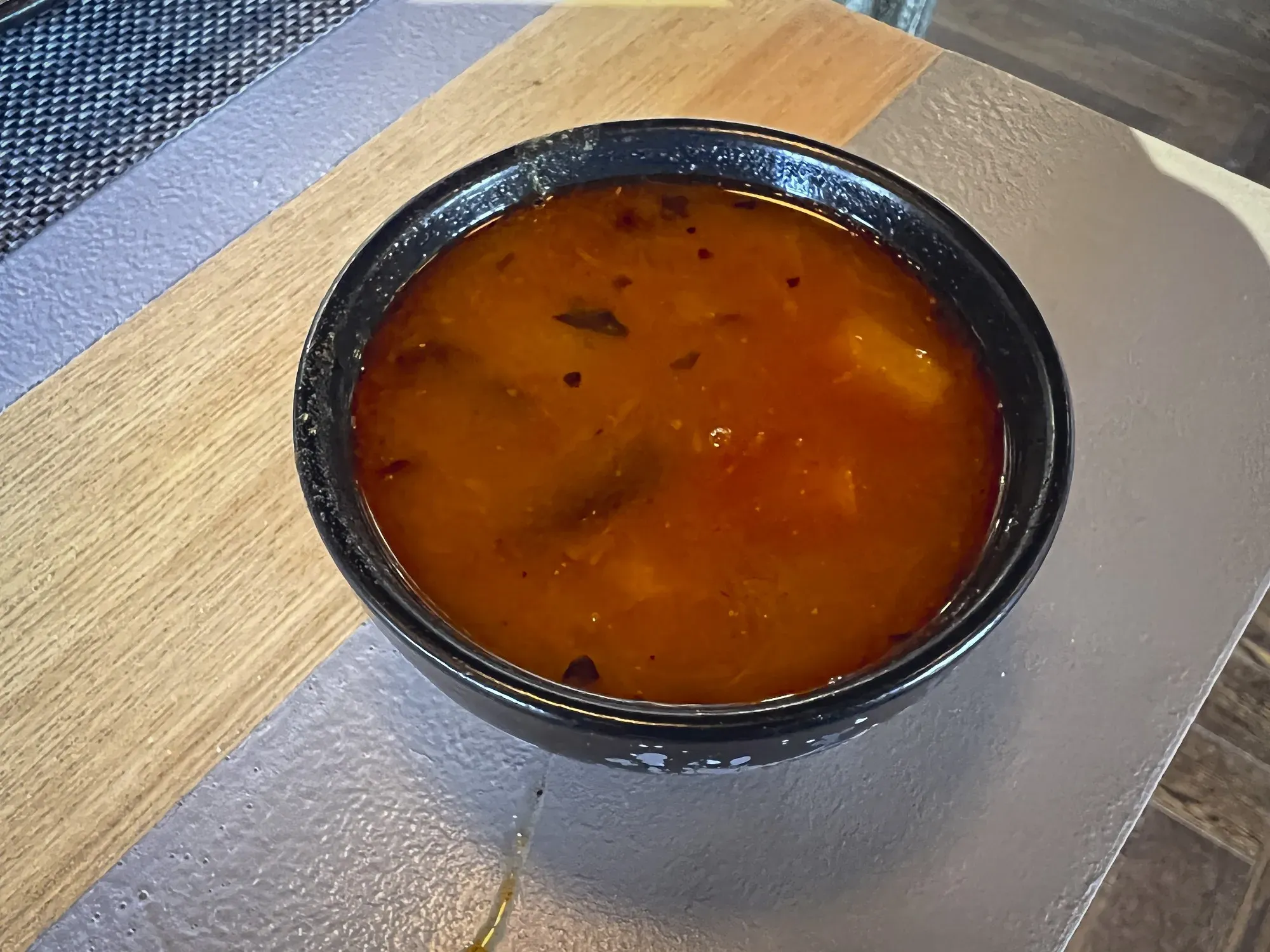 Angled shot of a small bowl of Sambar.