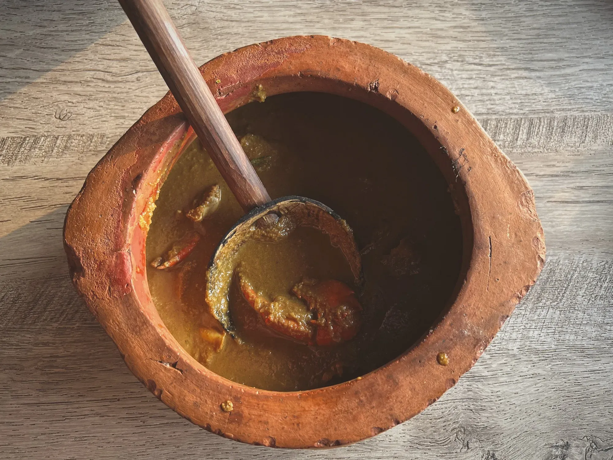 Clay bowl of Crab Xacuti, overhead shot.