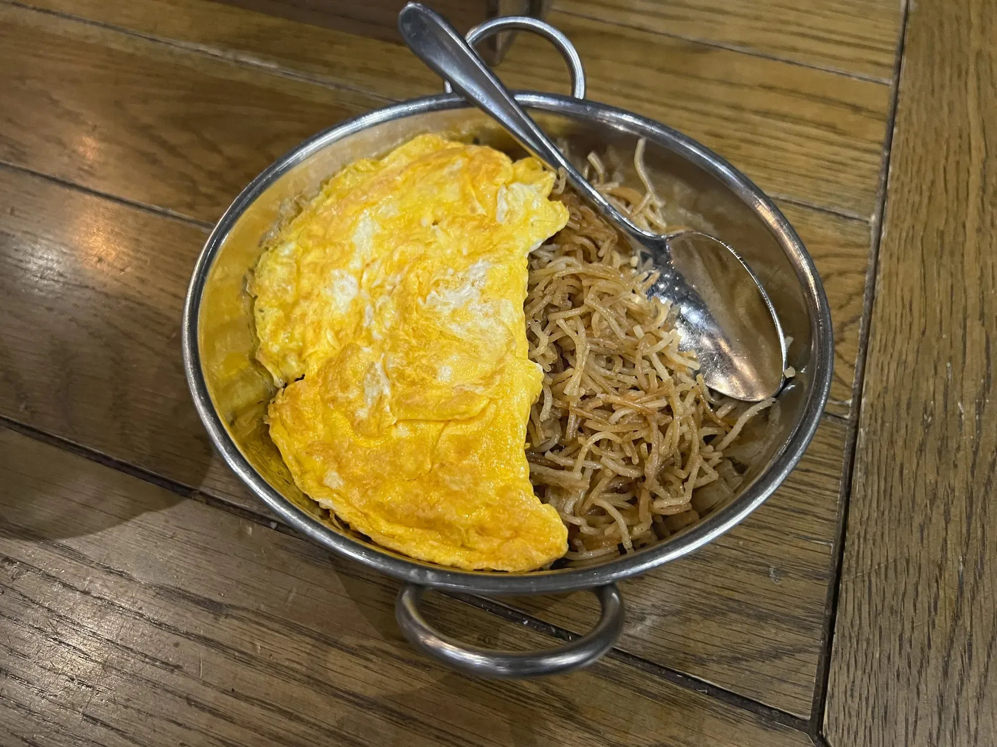 Bowl of Balaleet, angled shot. Vermicelli noodles half covered by egg.