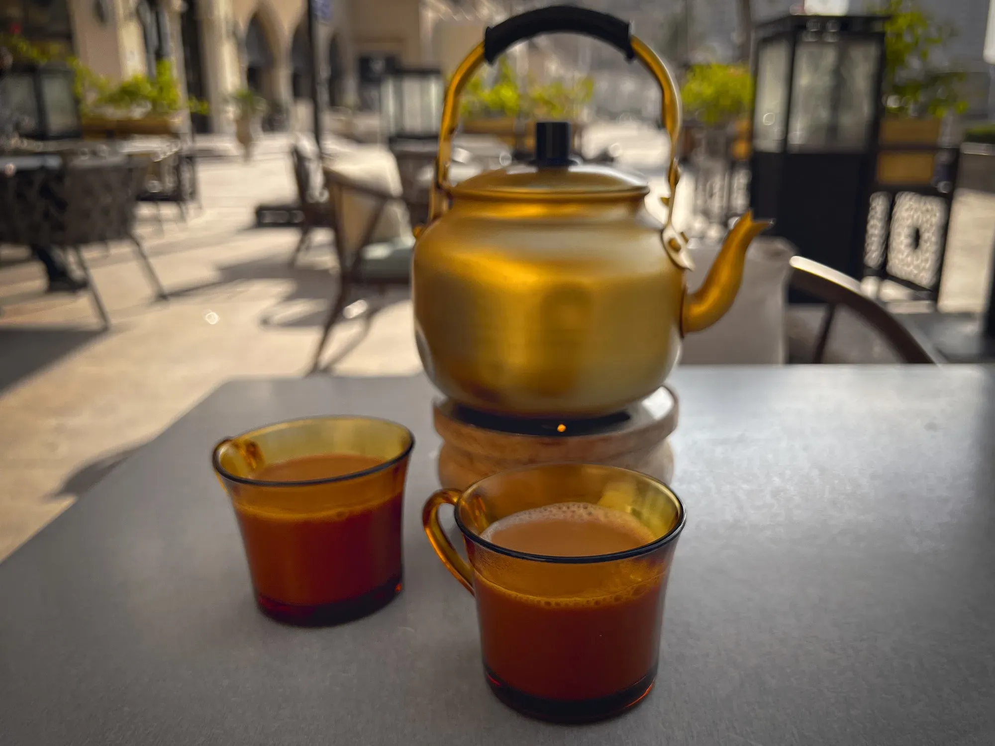 A pot and two cups of Karak tea, table shot.