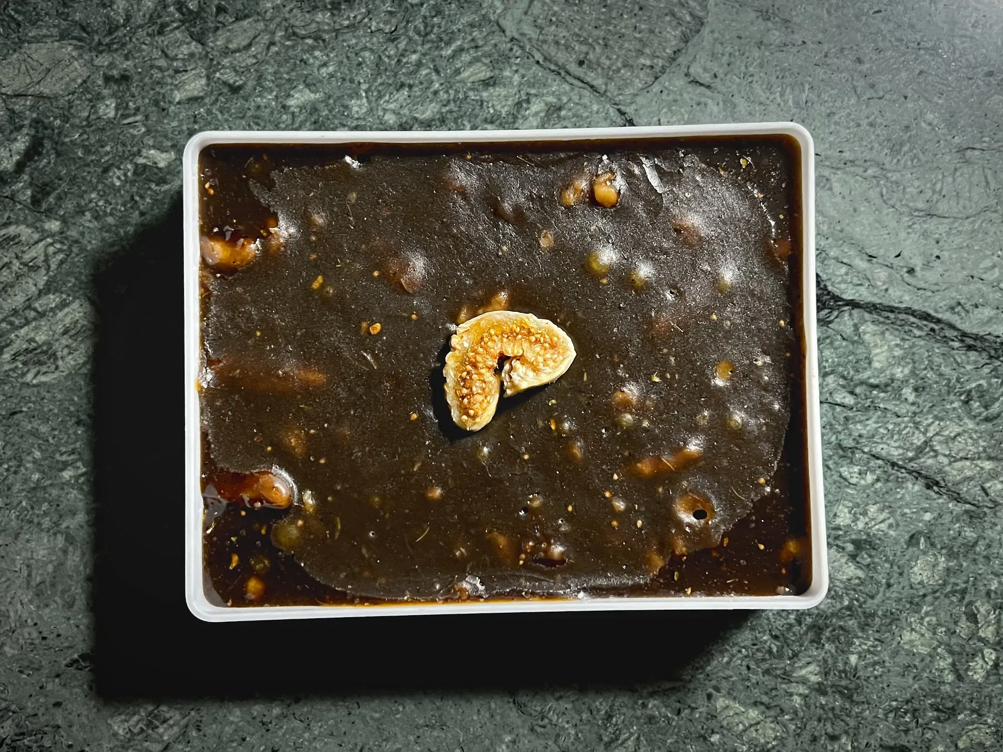 Omani Halwa with a cut fig in the middle, overhead shot.