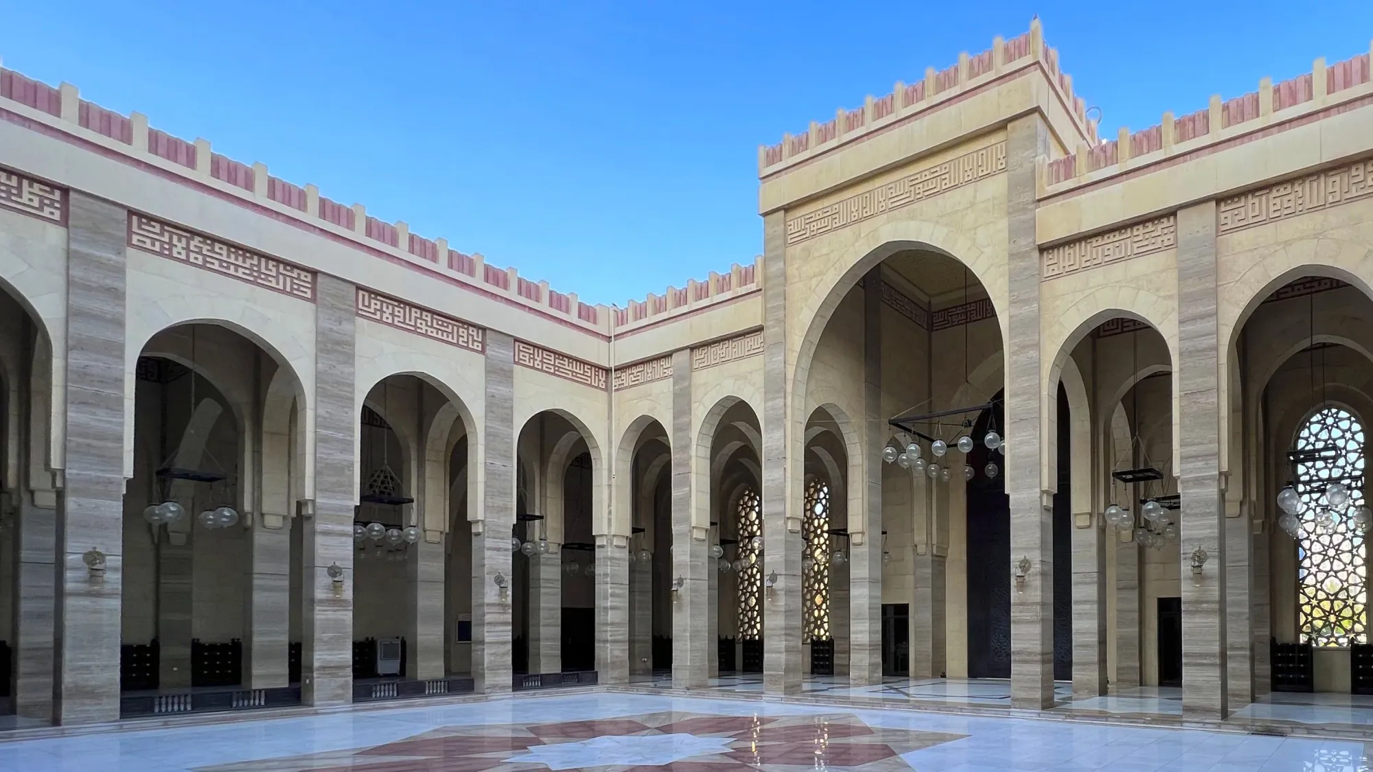 Marble floor with archways and windows with geometric latticework (jali)