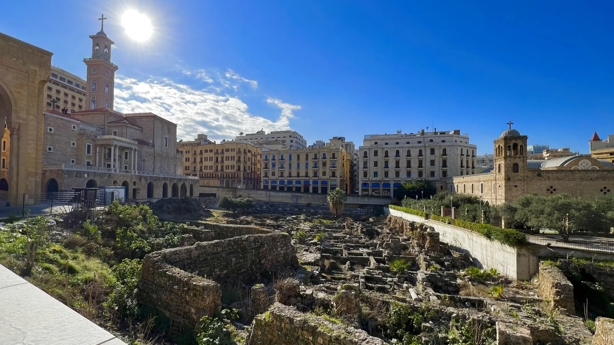 Ruins at the foot of a tan colored church building