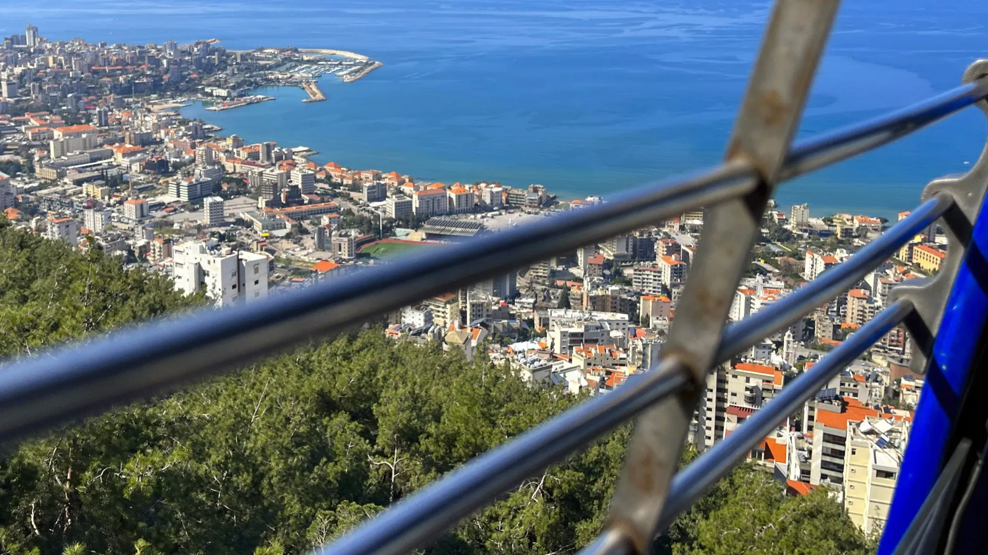 View through the bars in a cable car overlooking the city with orange roofs