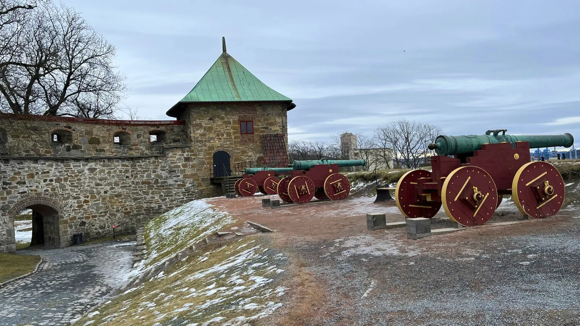 Red and green canons overlooking the stone fortress wall
