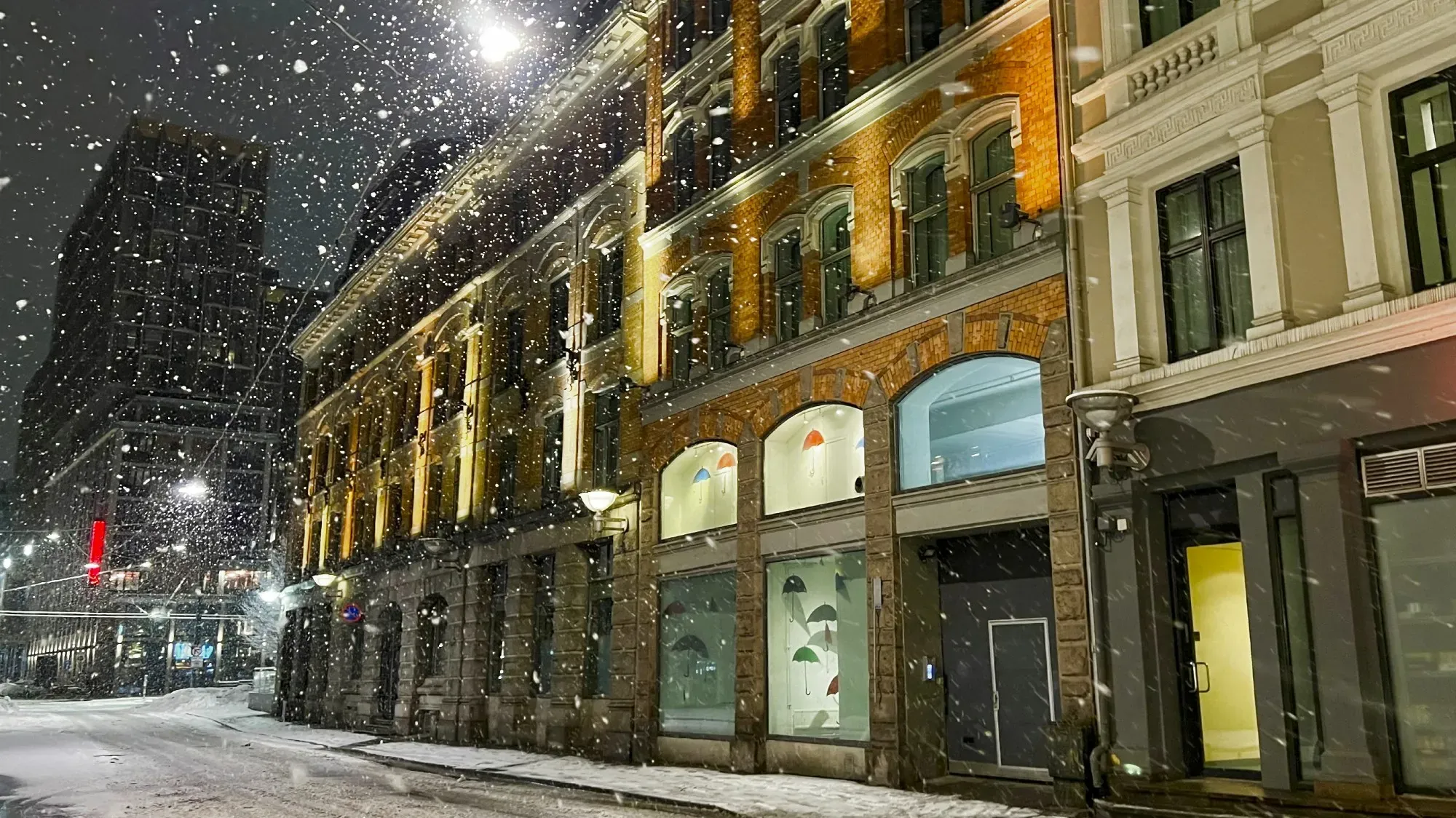 Snow falling at night on an Oslo street