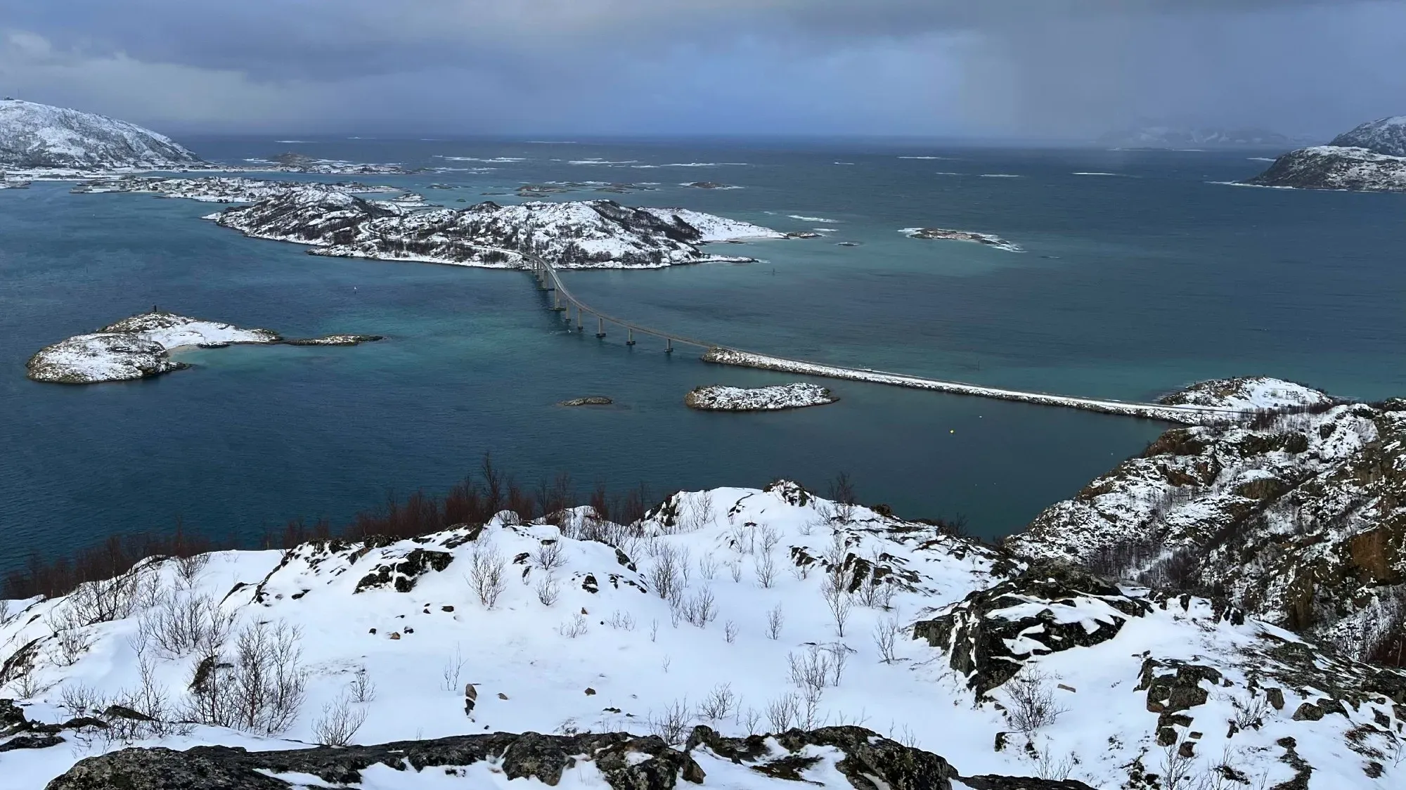 View of snowy hills overlooking the bridge connecting to Sommarøy island