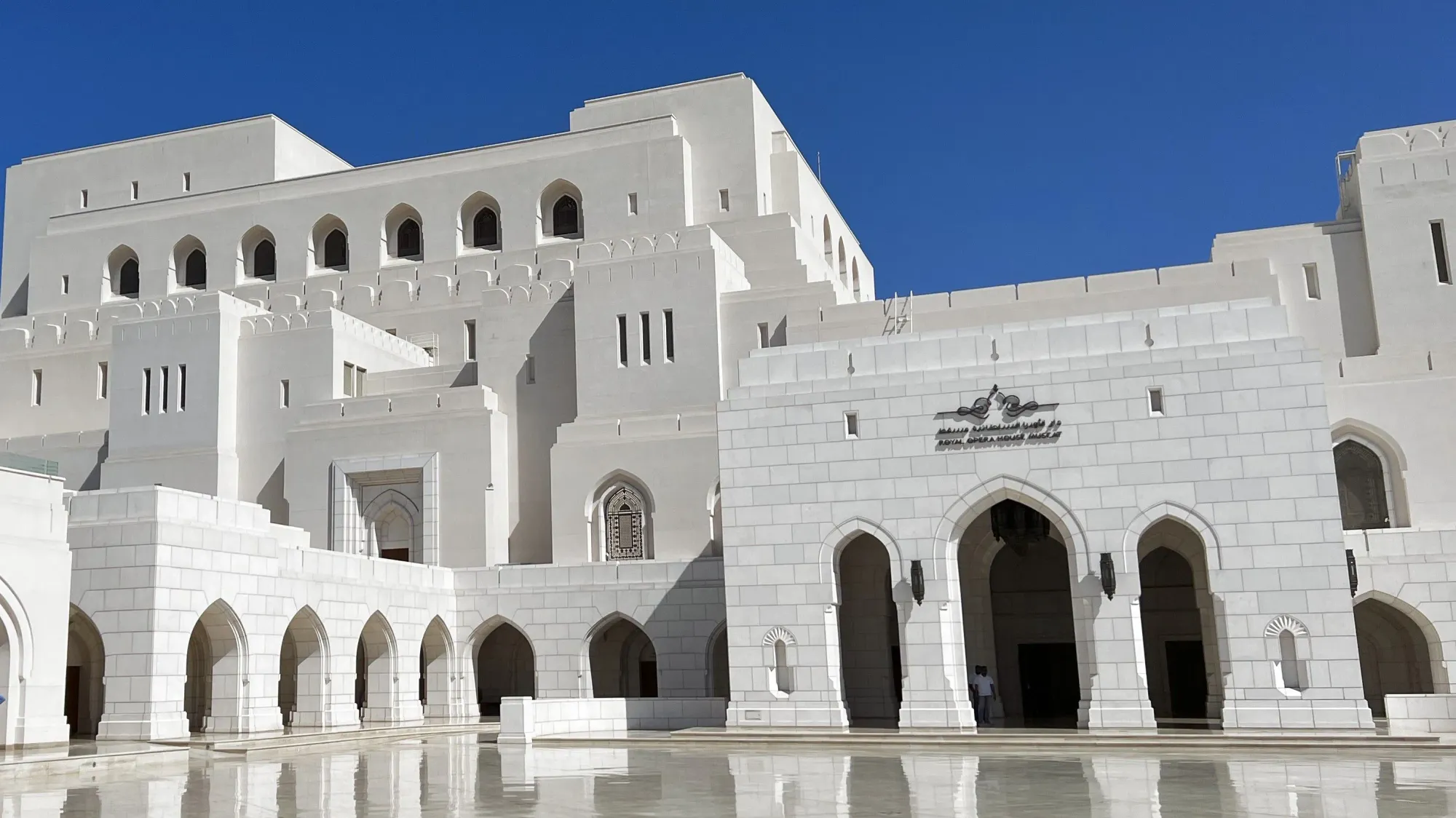 White stone building with multiple faces over marble courtyard