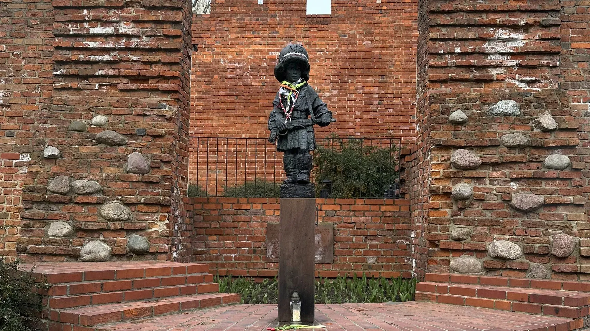 Statue of a little boy wearing a military helmet and carrying a weapon