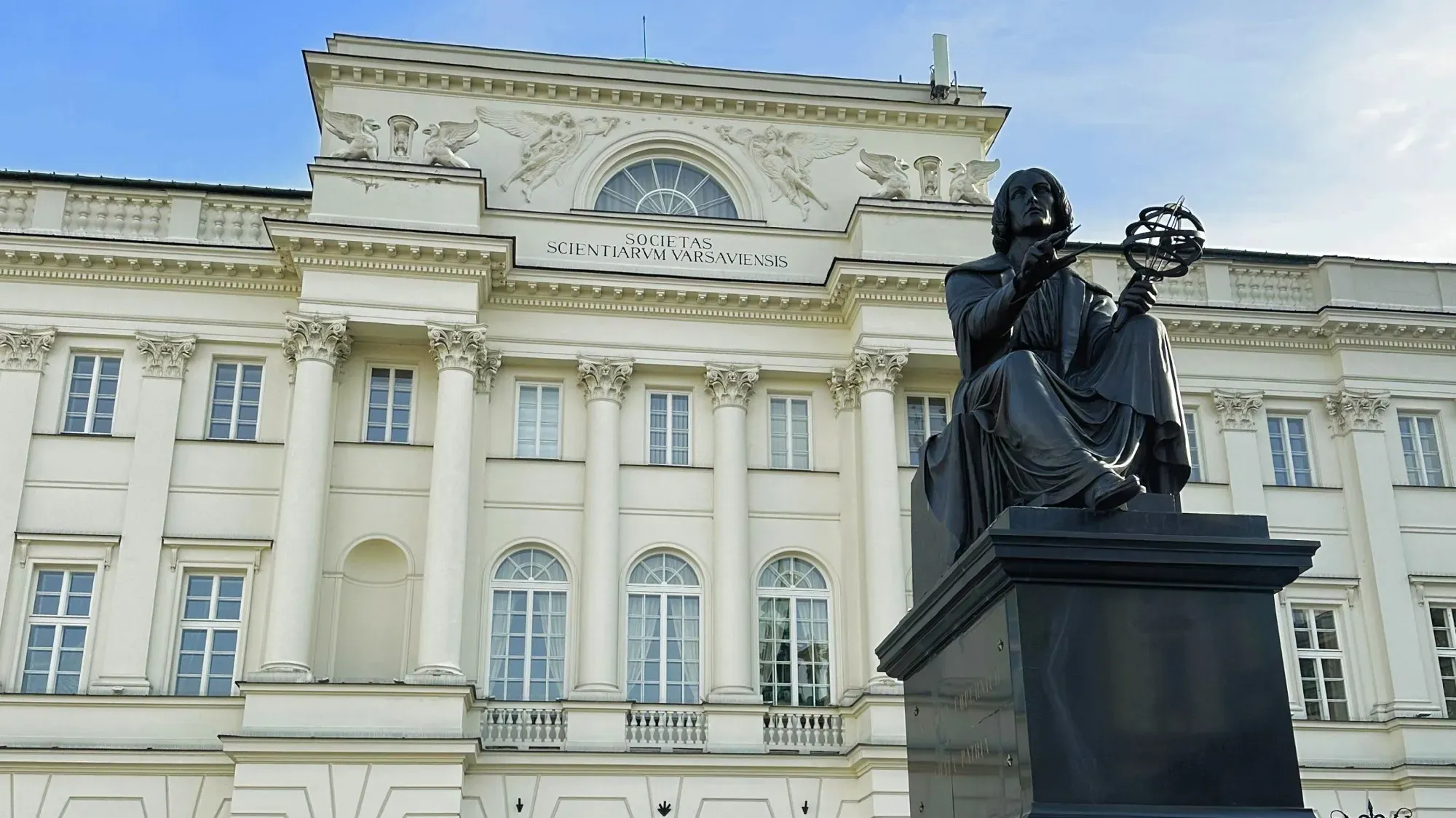 Black statue of Copernicus in front of the building for the Science Society of Warsaw