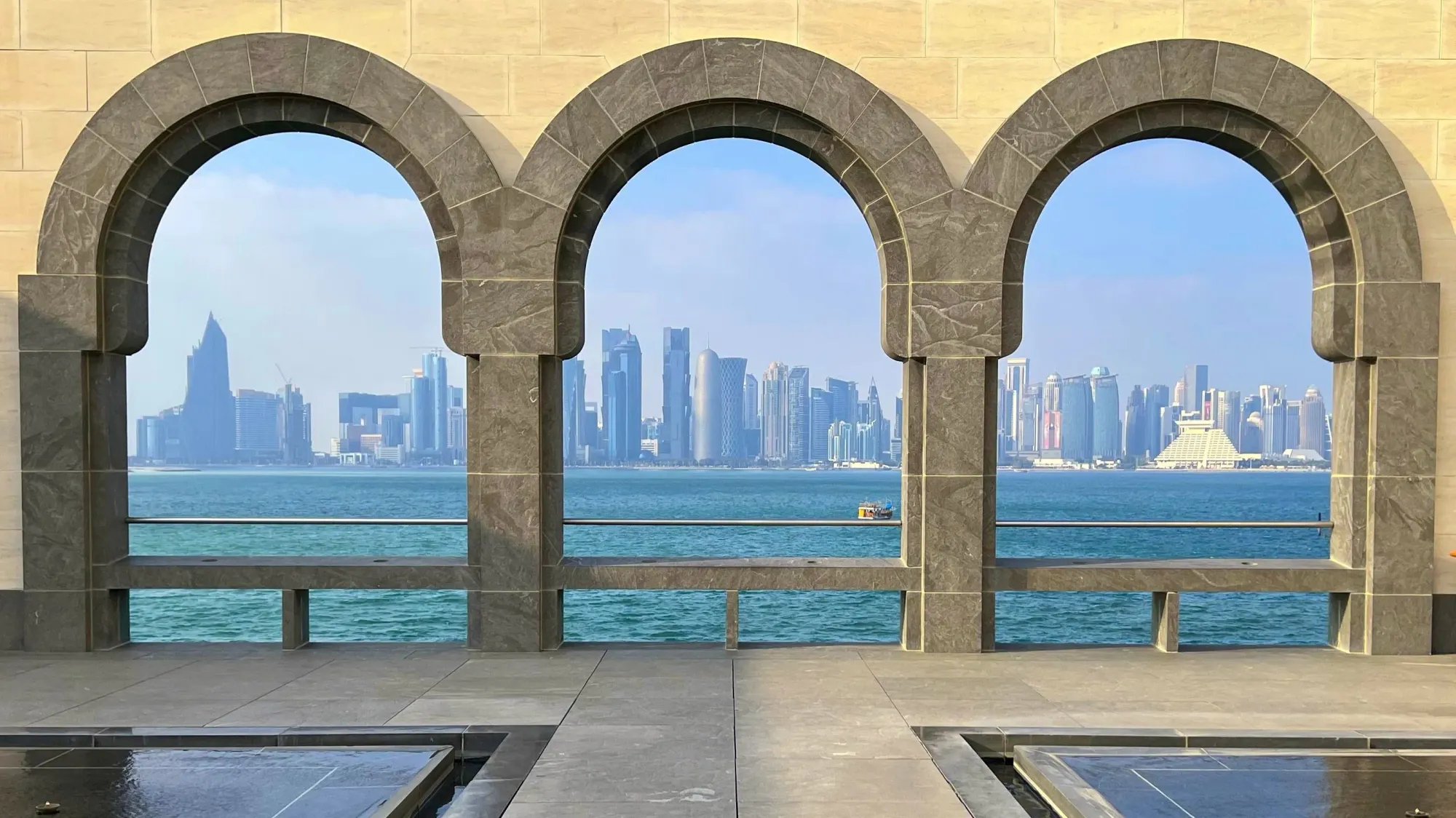 Three arches through which you can see downtown Doha