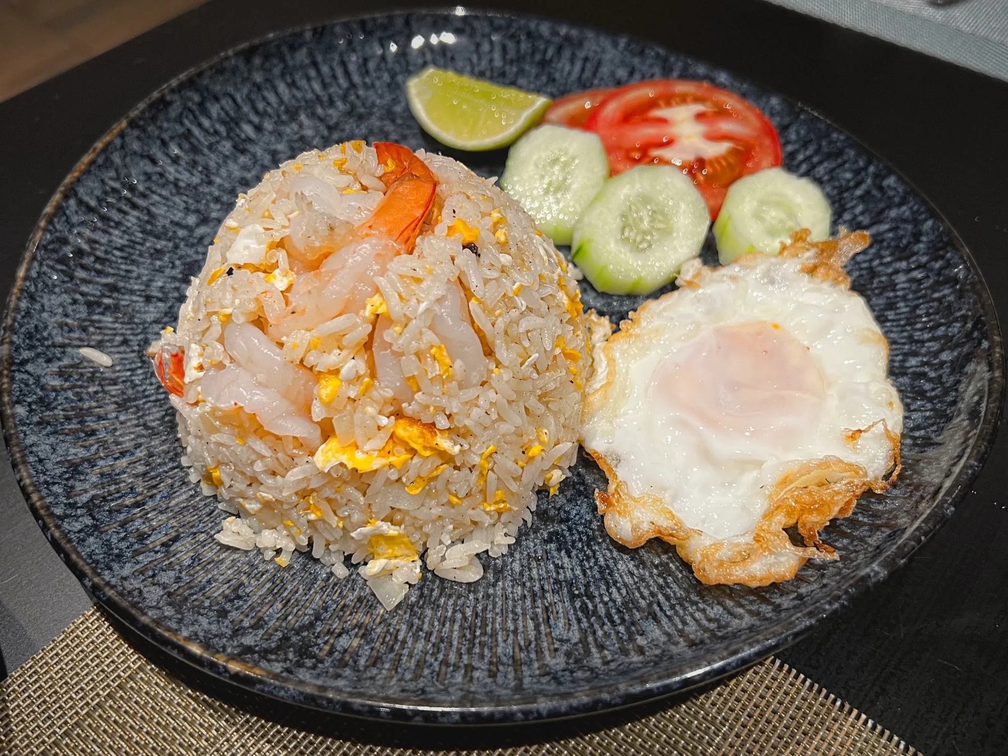 Plate with shrimp fried rice and a whole fried egg.