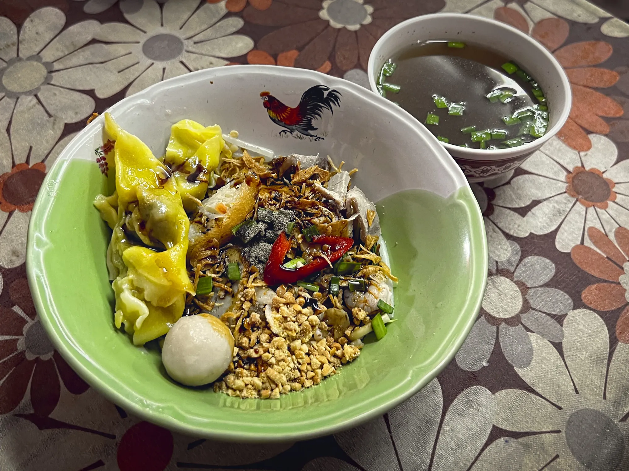 Mee Sapam in a bowl with a side of broth.