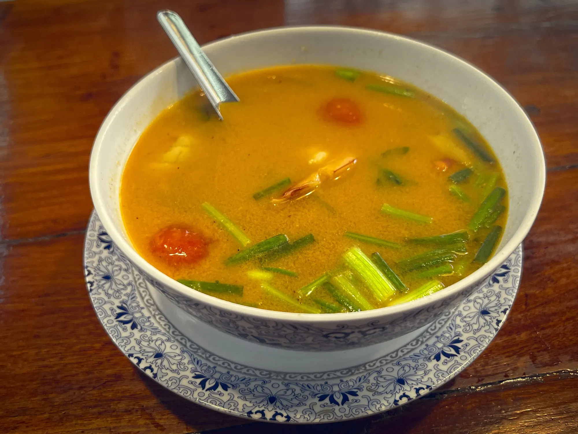 Tom Yum in a bowl, angled shot.