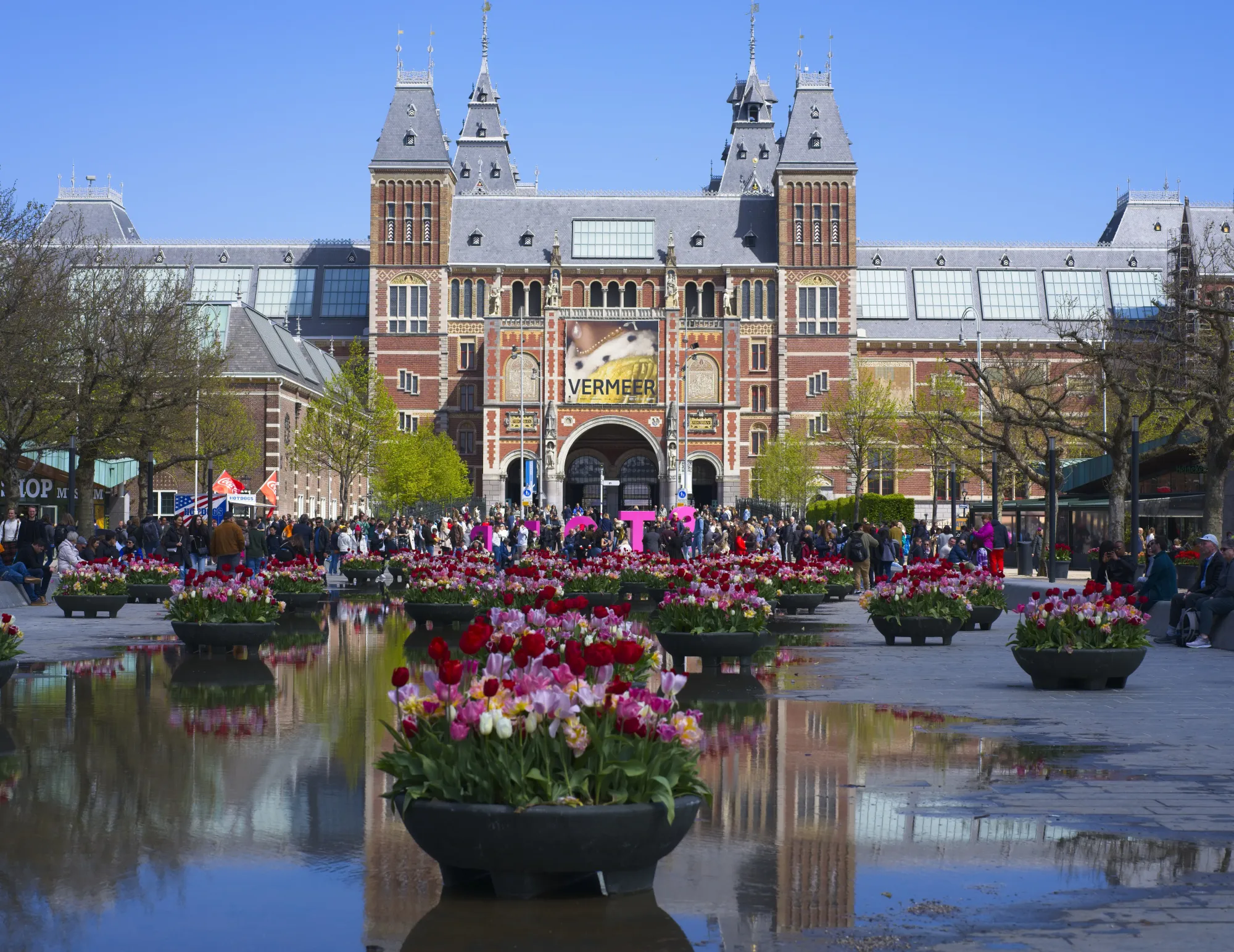 Museum reflected in a pool of water with basins of tulips