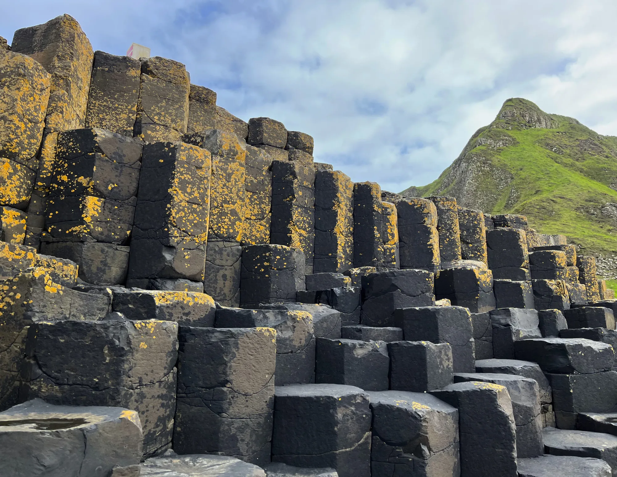 Black basalt pillars with a mountain set behind them