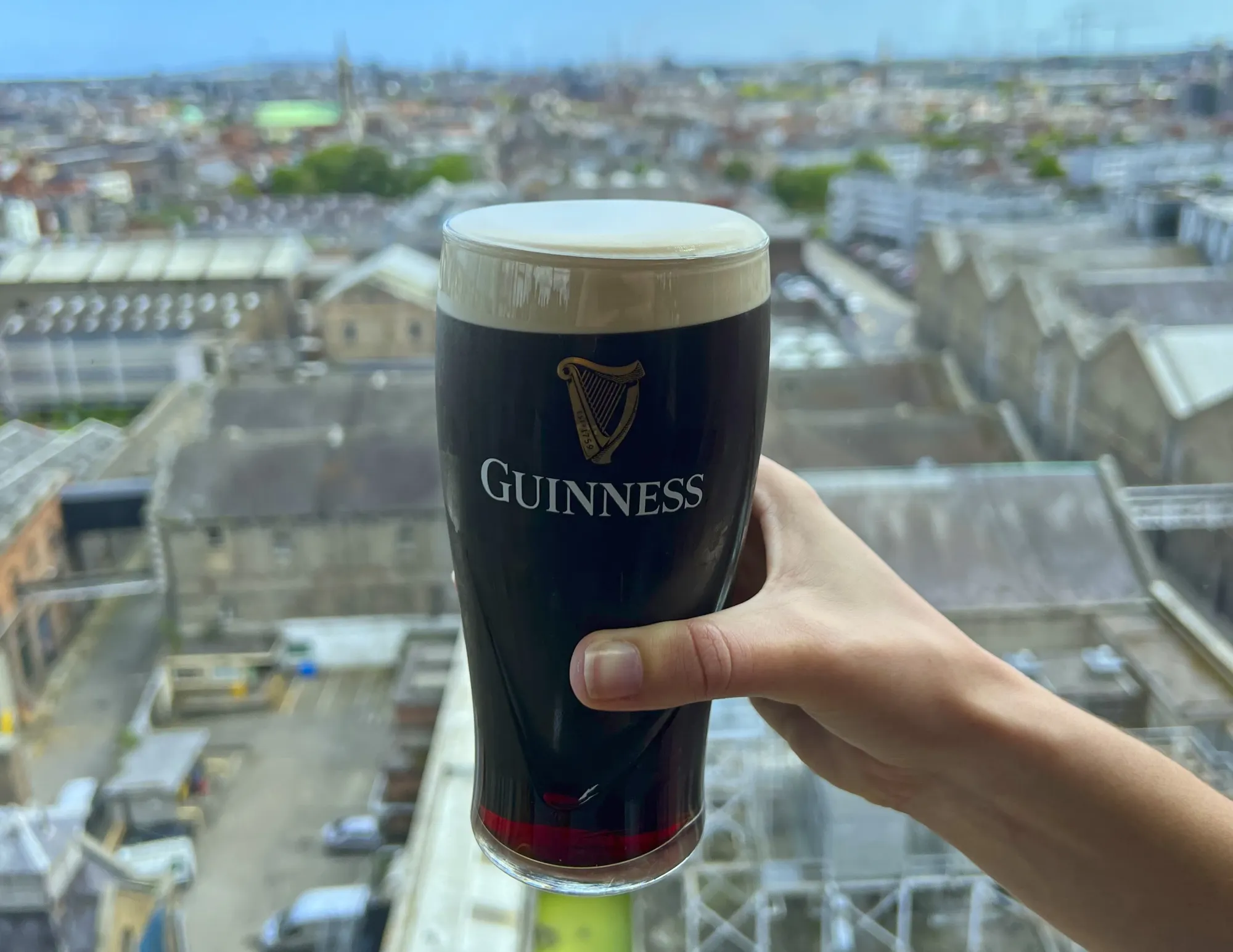 Hand holding a pint of Guinness