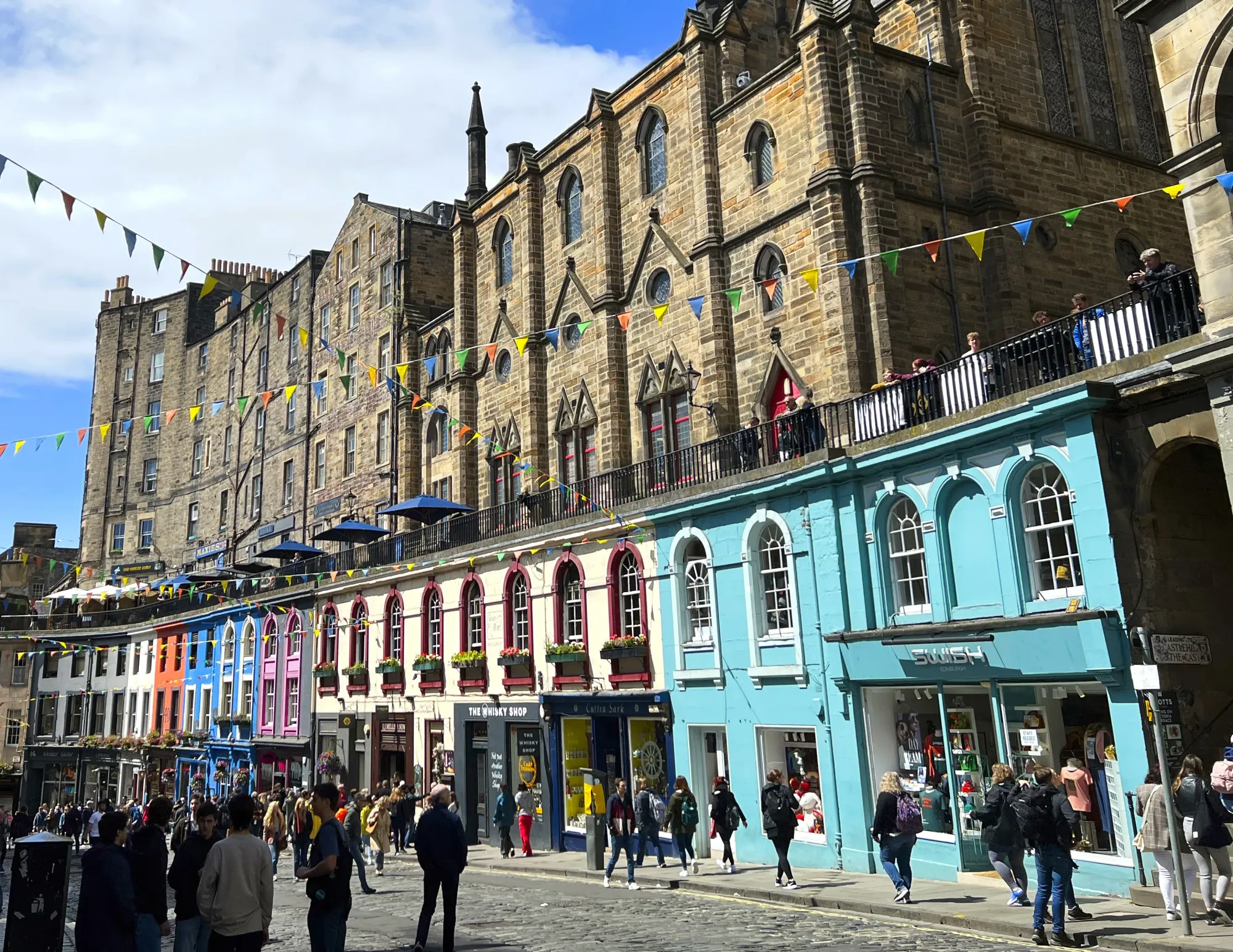 Colorful store fronts with decorative flags and pedestrians