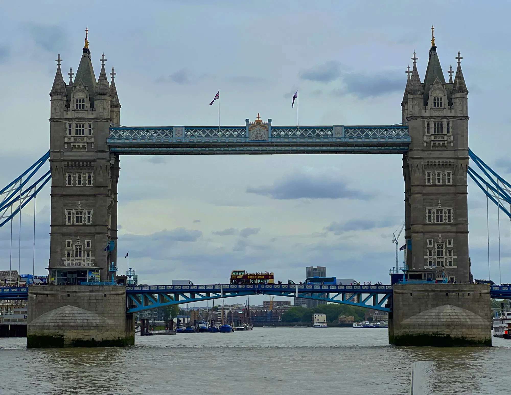Bridge with two towers on either end and a double decker bus riding across it