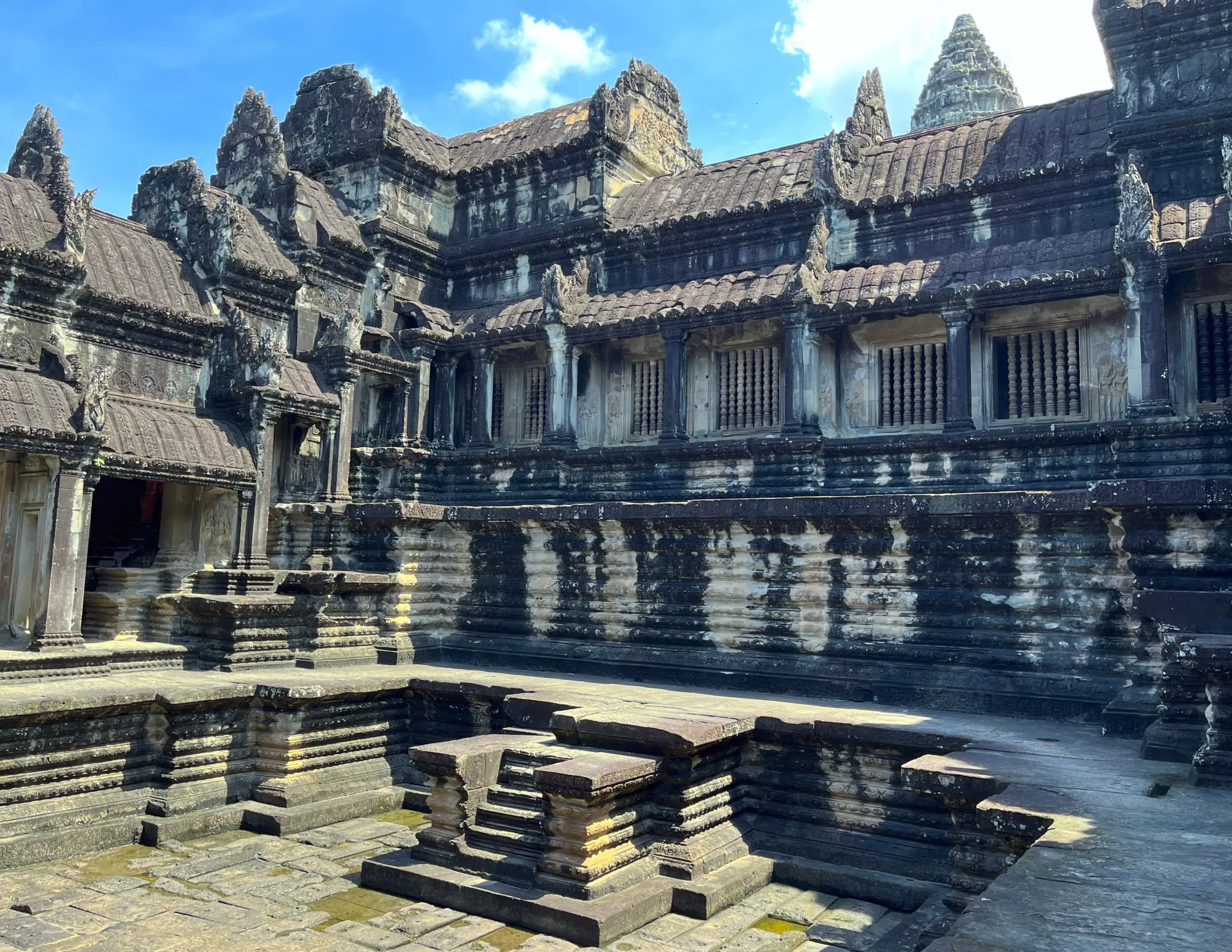 Grey stone temple with the remains of a pool