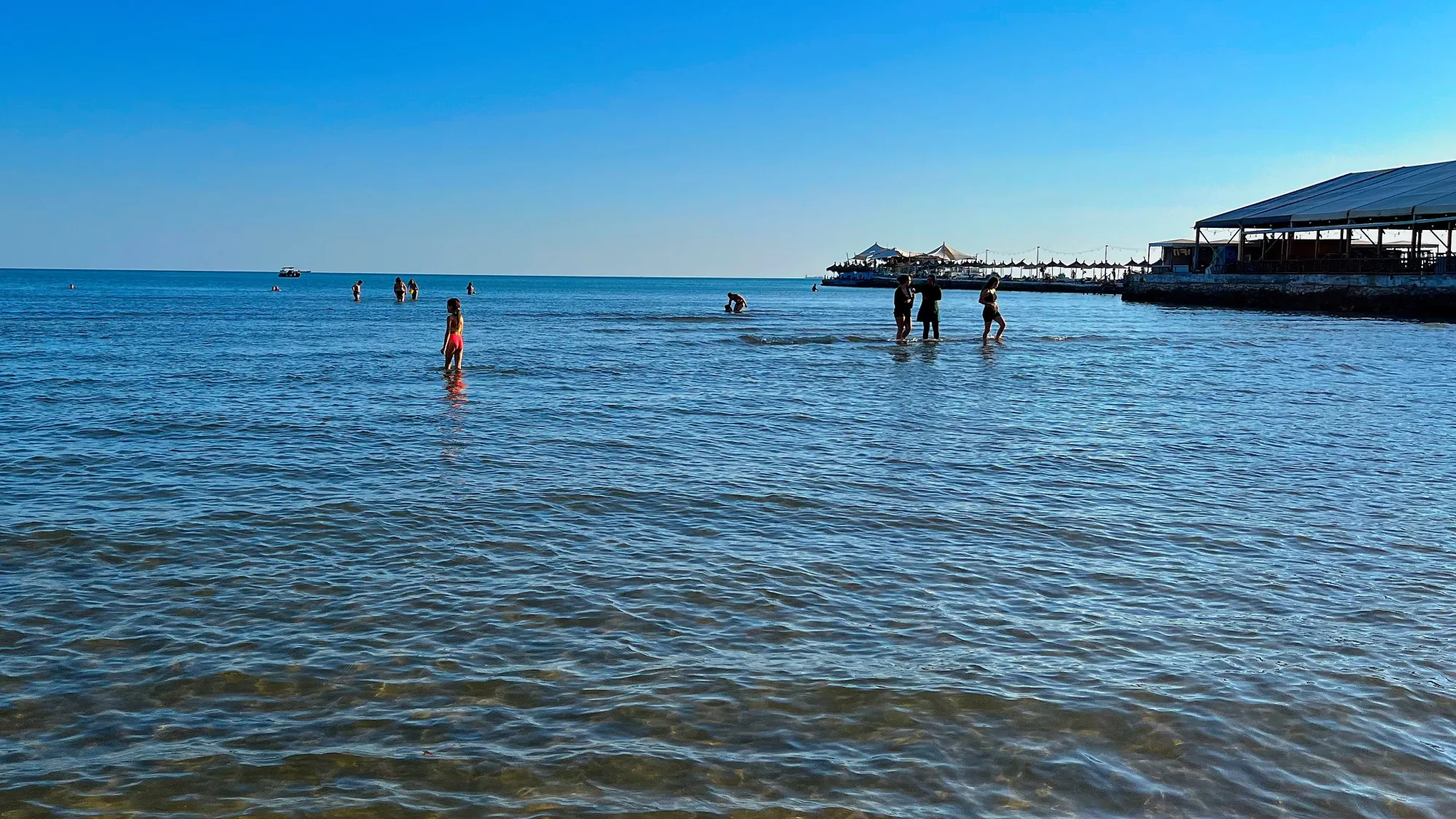 Shallow beach water with families standing inside