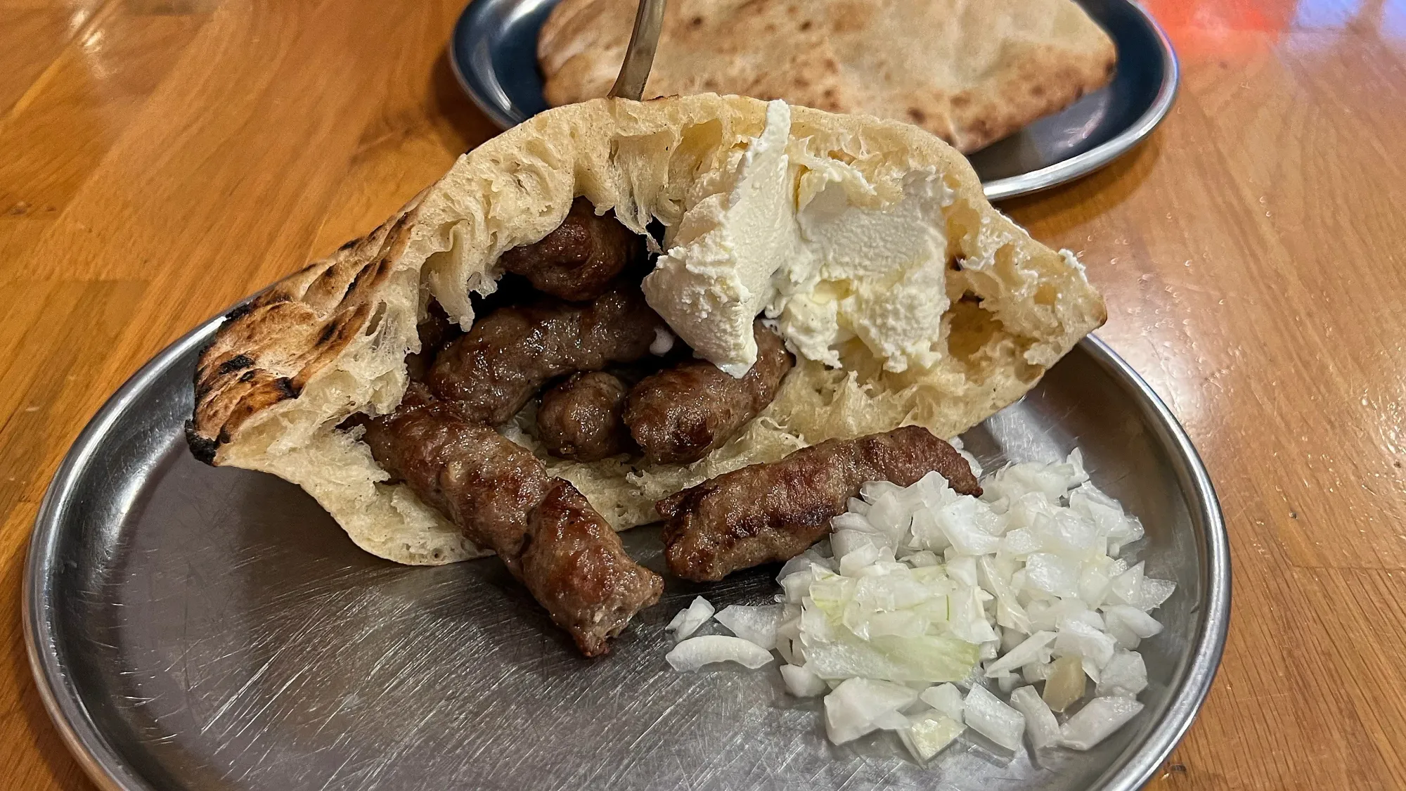 Open bread pocked with meat, cheese, and onions on a silver plate