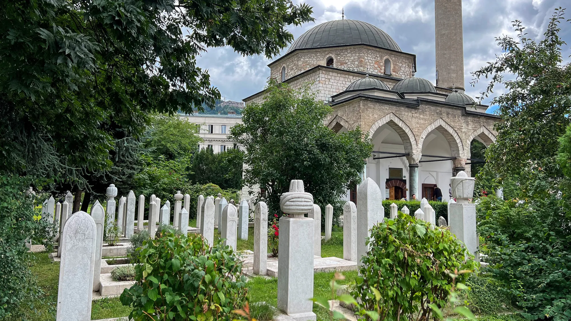 White brick mosque with skinny marble headstones