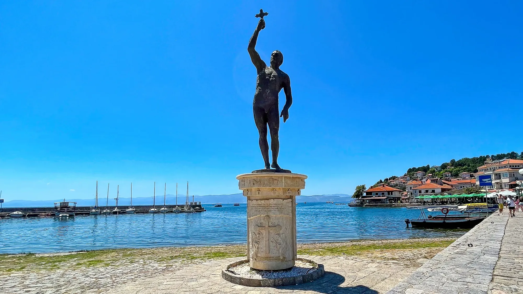 Statue of a man holding a small cross above his head