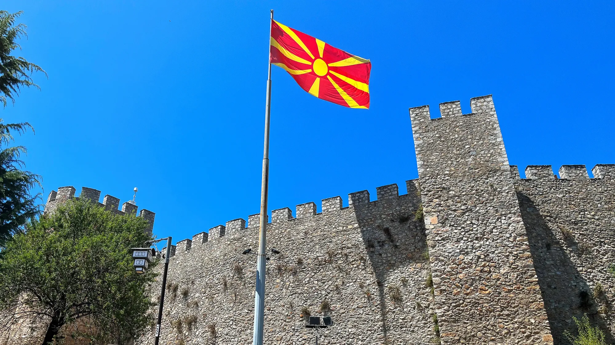 Stone ramparts with the North Macedonian flag flying overhead