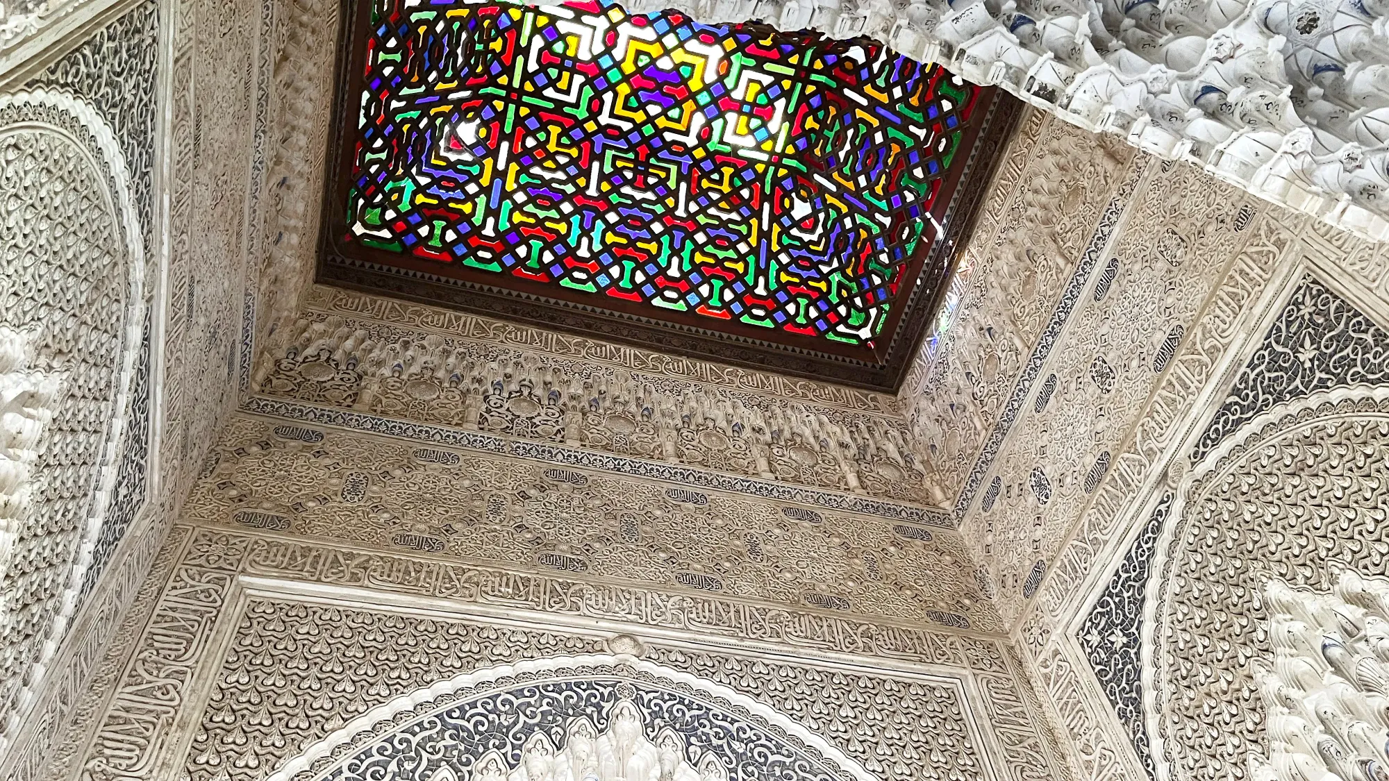 White tiled walls with red, yellow, and blue stained glass ceiling