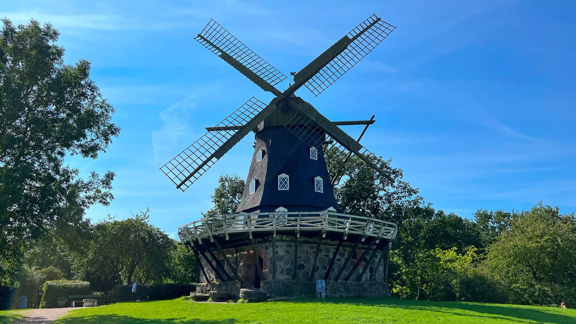 Wooden windmill on a green hill