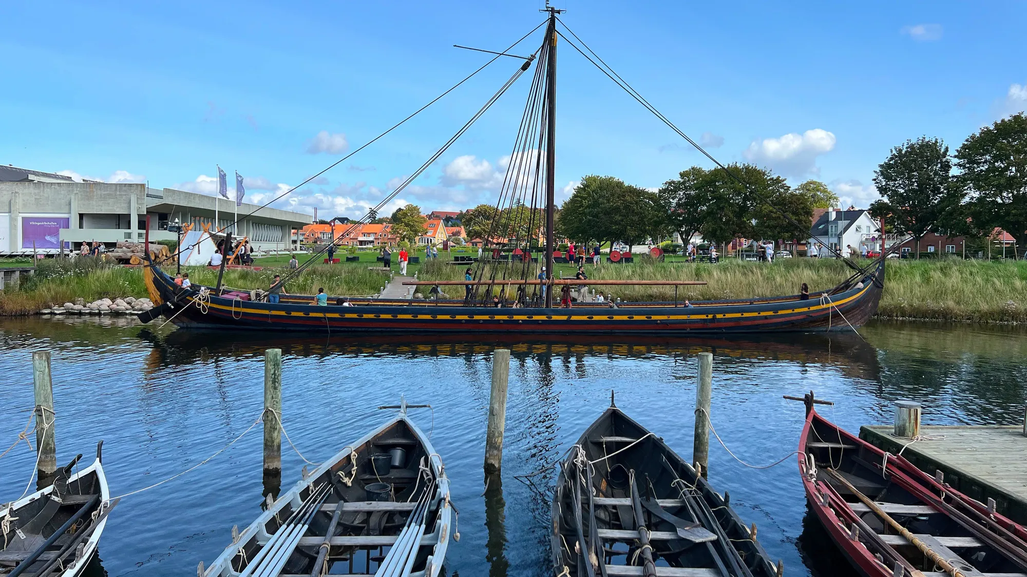 Long wooden boat with four smaller ones in front of it